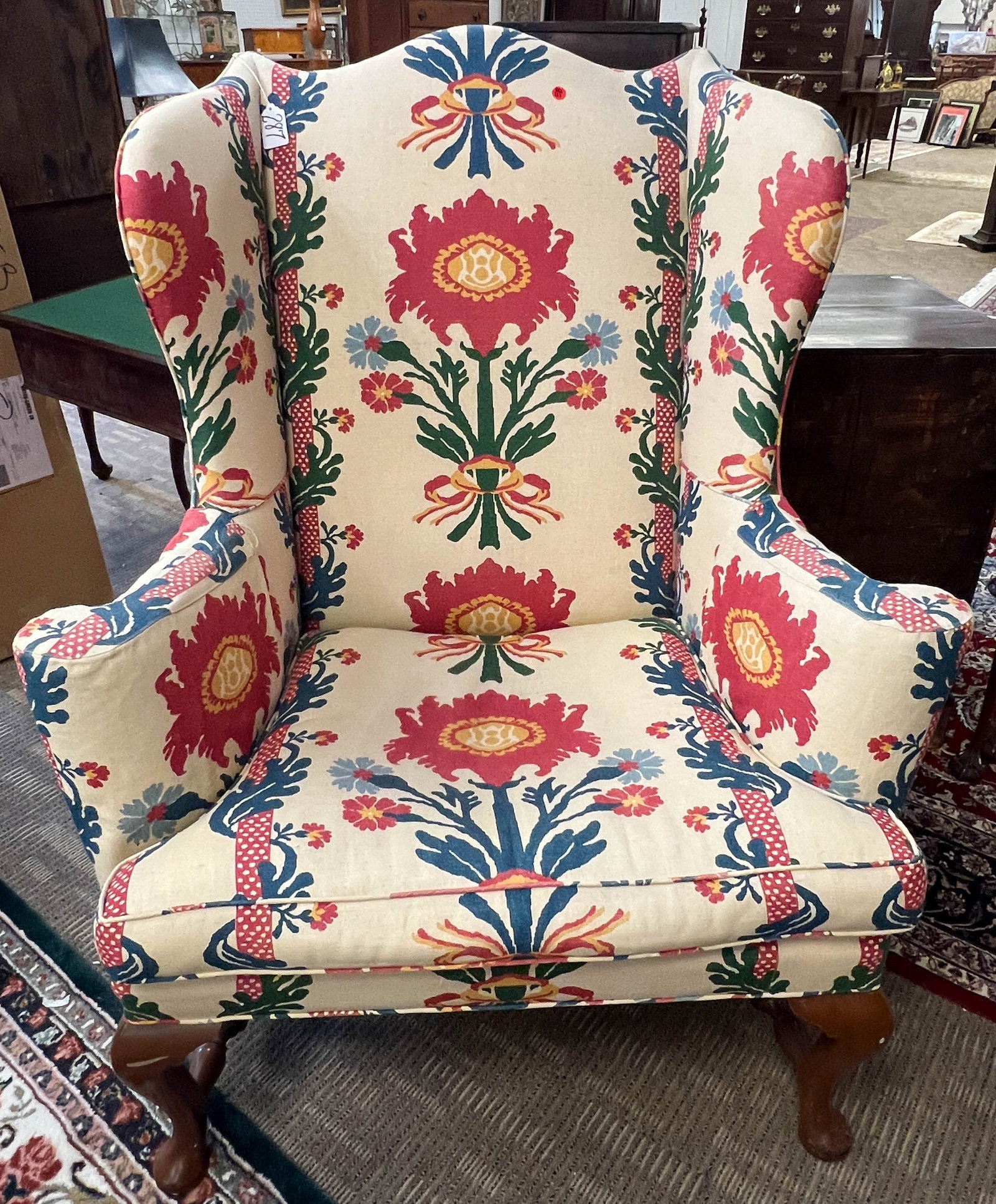 Queen Anne Wing Chair In Schumacher Upholstery: A quality Queen Anne mahogany trimmed wing chair in Schumacher floral upholstery down filled. It is attributed to Kittinger. It measures 45" x 22" x 37". It house ready
