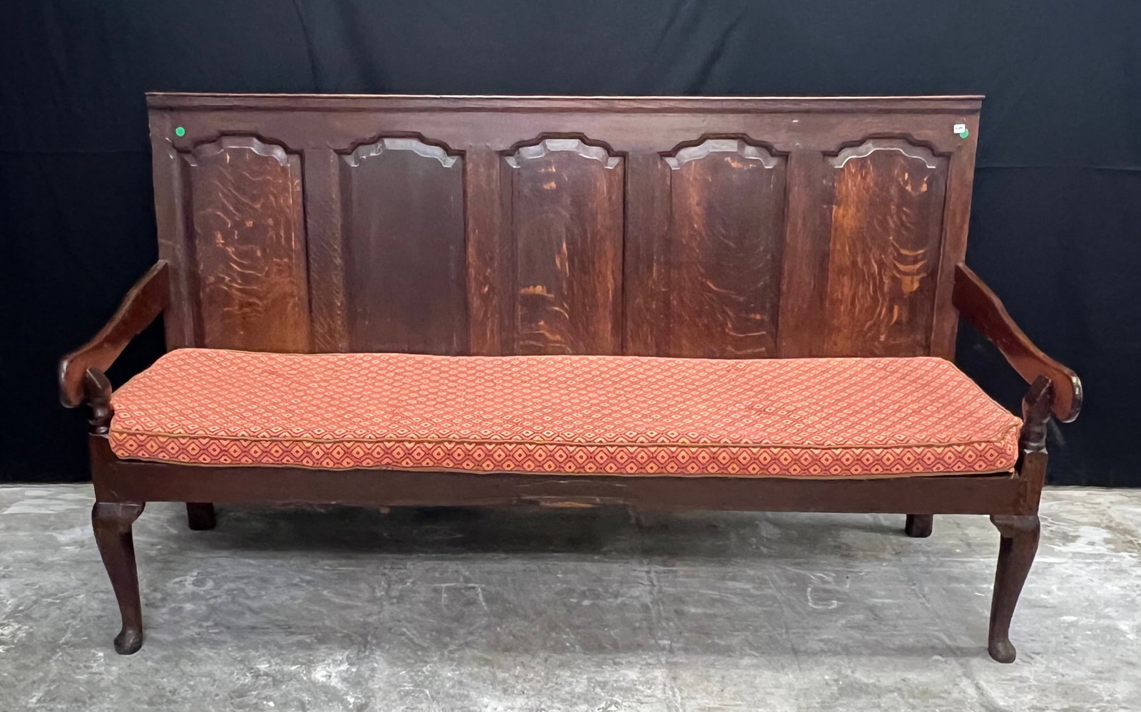 Antique English Oak Armed Pub Bench c1720/30's: An antique English armed pub bench from 1720's-1730's with high back and Queen Anne legs. This serpentine bench with chamfered back panels is in its original fumed oak finish with dovetailed and pegge