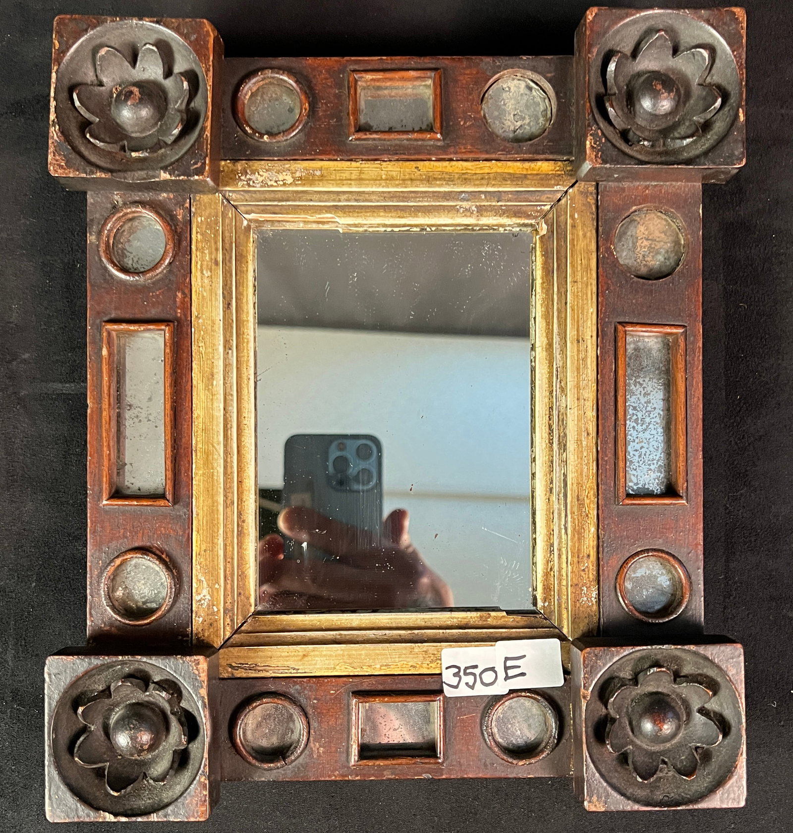 A Folk-art Hand Carved Mirror 1790-1810: An antique folk art mahogany mirror with mirrored insets and carved rosettes. This folk art mirror is in its original finish and measures 10" tall x 9" wide.