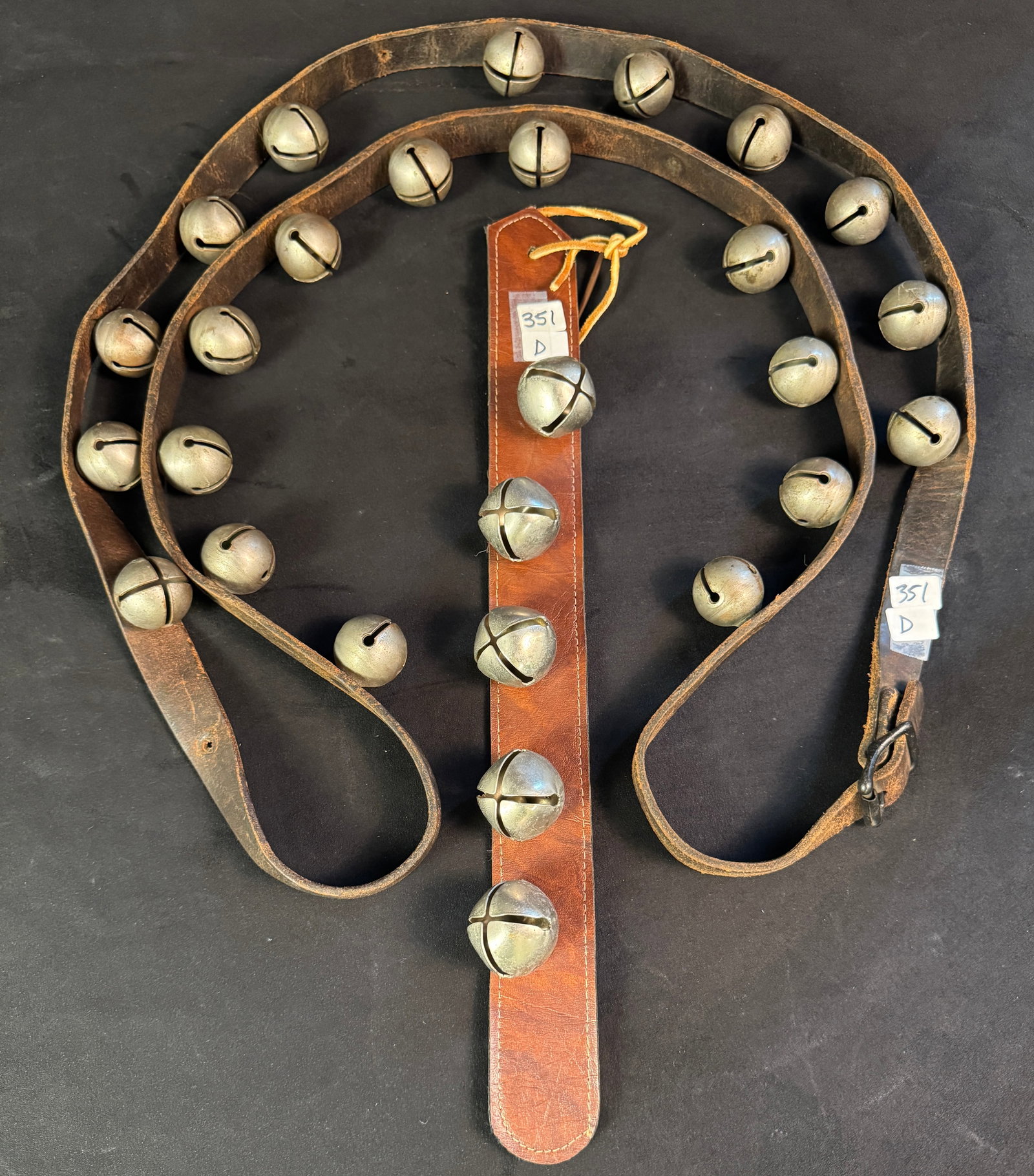Long Strand of Antique Sleigh Bells: Long strand of antique sleigh bells, measures approximately 92"l, with original leather strap & buckle.