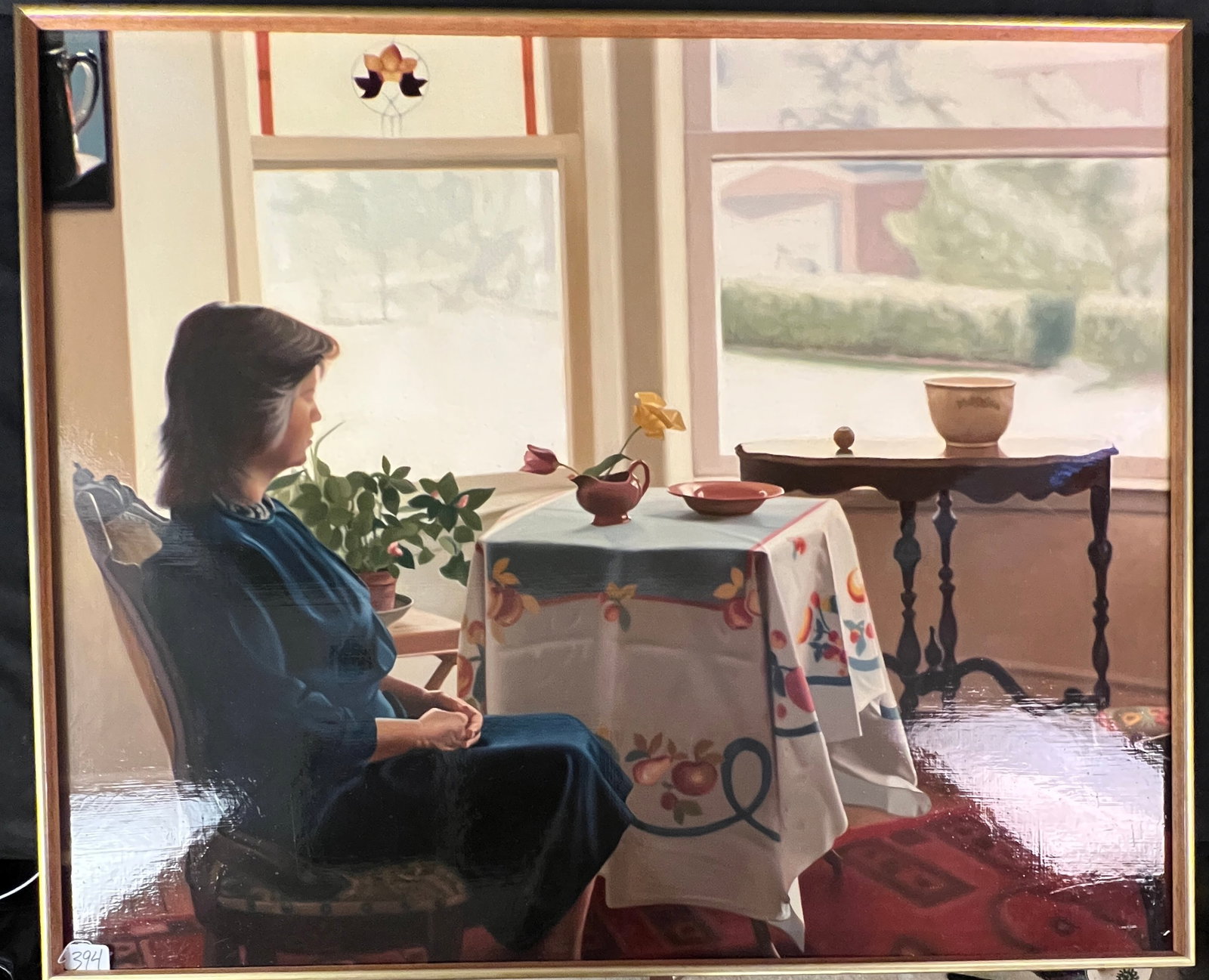 John Sayers Oil on Masonite c. 1986: A large John Sayers (b. 1950) oil painting on Masonite board depicting a woman at a small table gazing out a large window. The painting features his signature tablecloth and flowers. Signed and dated 