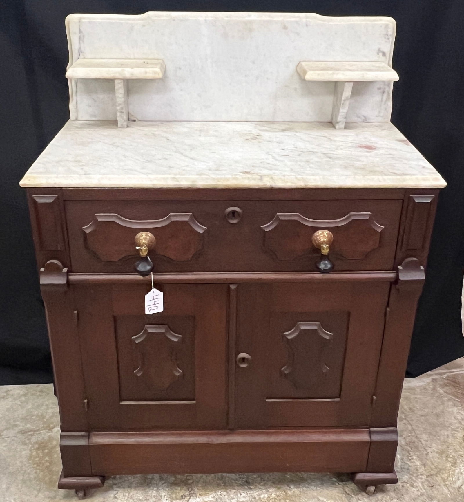 Walnut Victorian Marble Top Commode: A walnut Victorian marble top commode with back splash, candle shelves, scalloped panels with burled fronts, and antique teardrop polls. This wonderful drawer over double door marble top commode is in