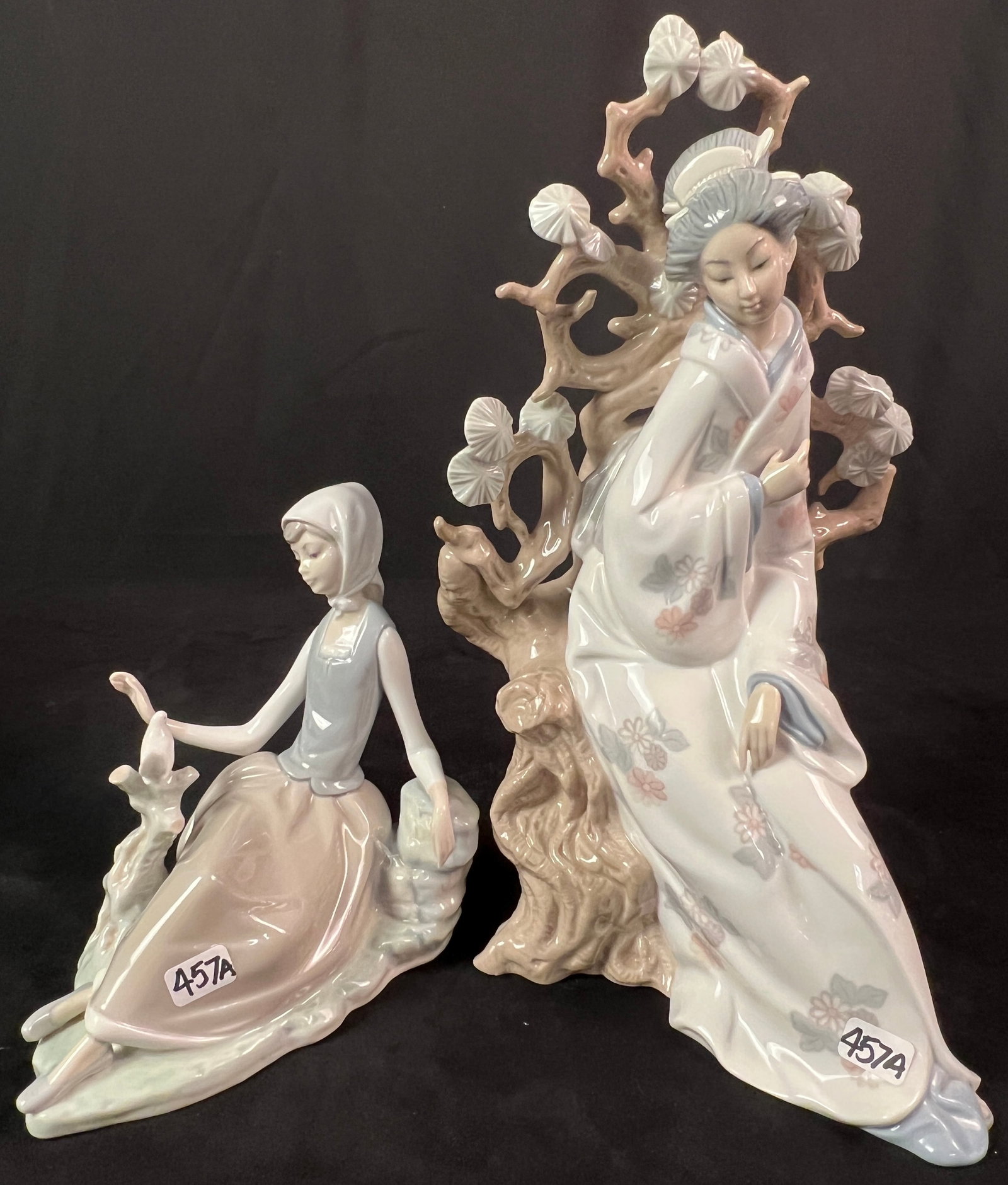 2 Vintage Lladro Figurines c1960's: 2 Vintage porcelain Lladro figurines to include seated Lady with Dove in excellent condition that measures 7" tall X7" across, and a Geisha in a tree that measures 12" tall X 6" across X 8" deep (miss