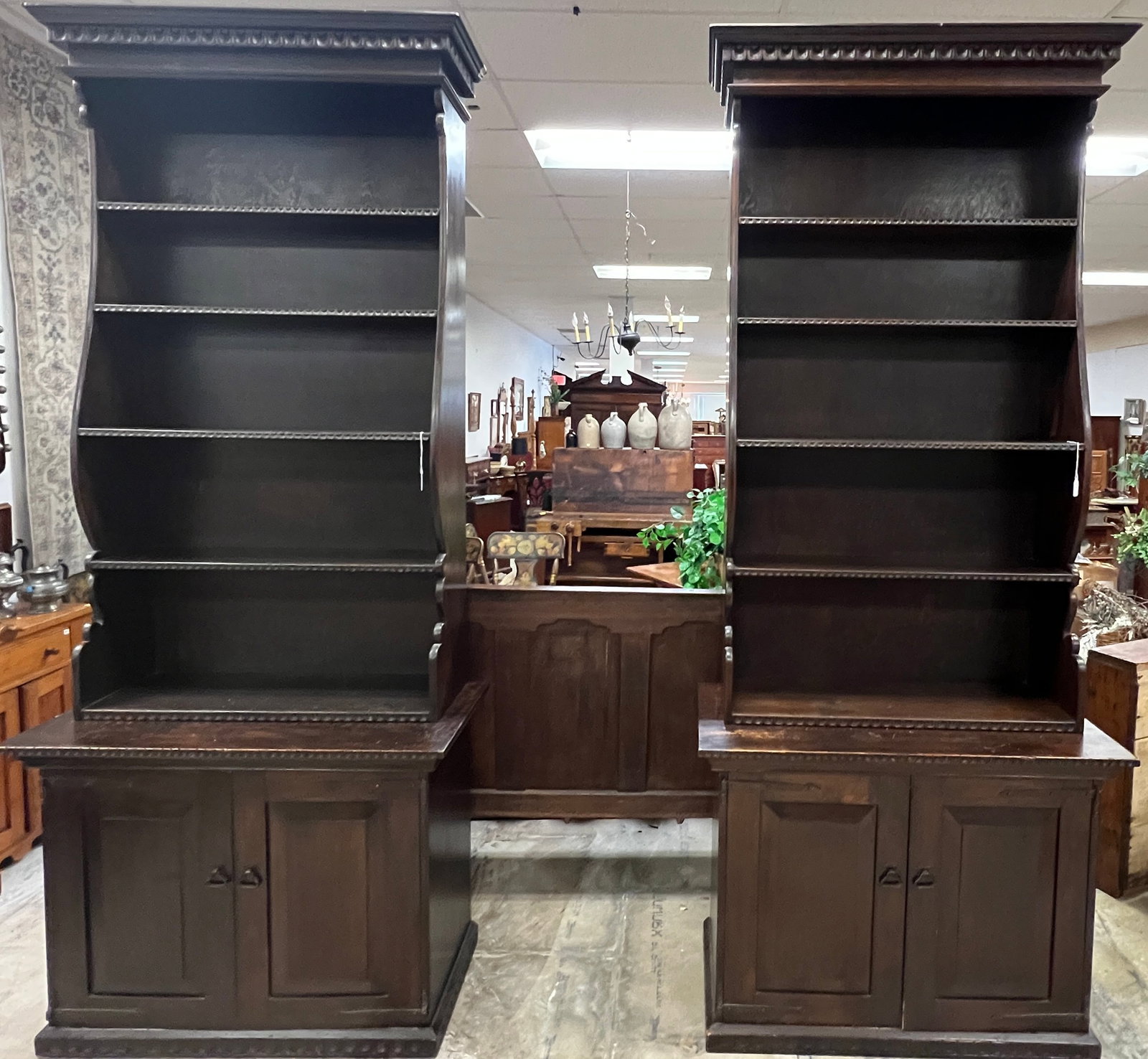 Custom Pine Compartment base Bookcases, Pair: A 1920's mahogany library table with carved supports and drawer in good condition.. It features pendentive crown trim, and hand forged hardware. It measures 96" tall X 21" across X 18" deep.
