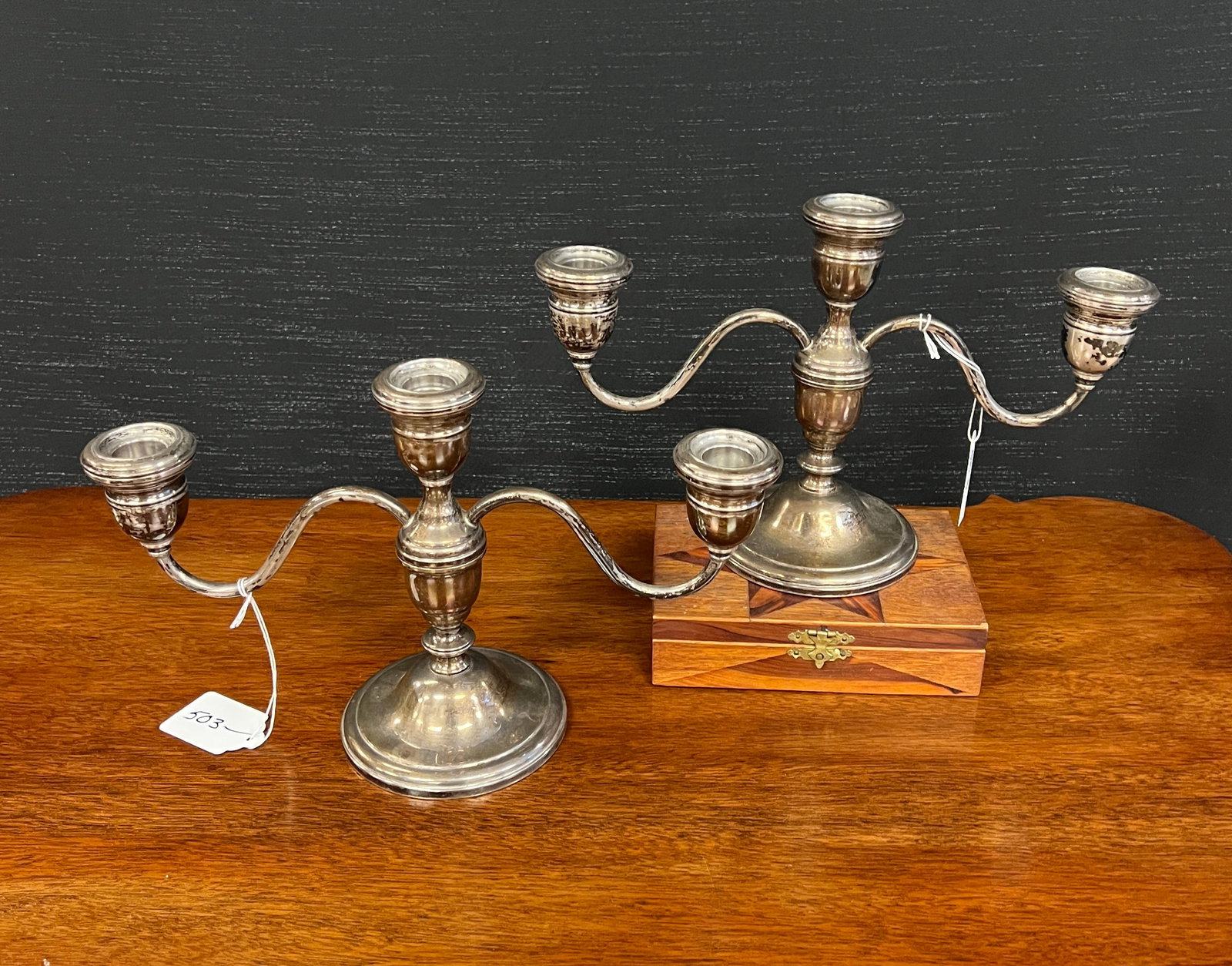 A Pair of Sterling Weighted Candelabras: A pair of three arm sterling weighted candelabras in good condition. They weigh 1810g or 63.85oz but this is not accurate because they are weighted. They measure 7.5" tall x 12.5" wide x 2" deep.