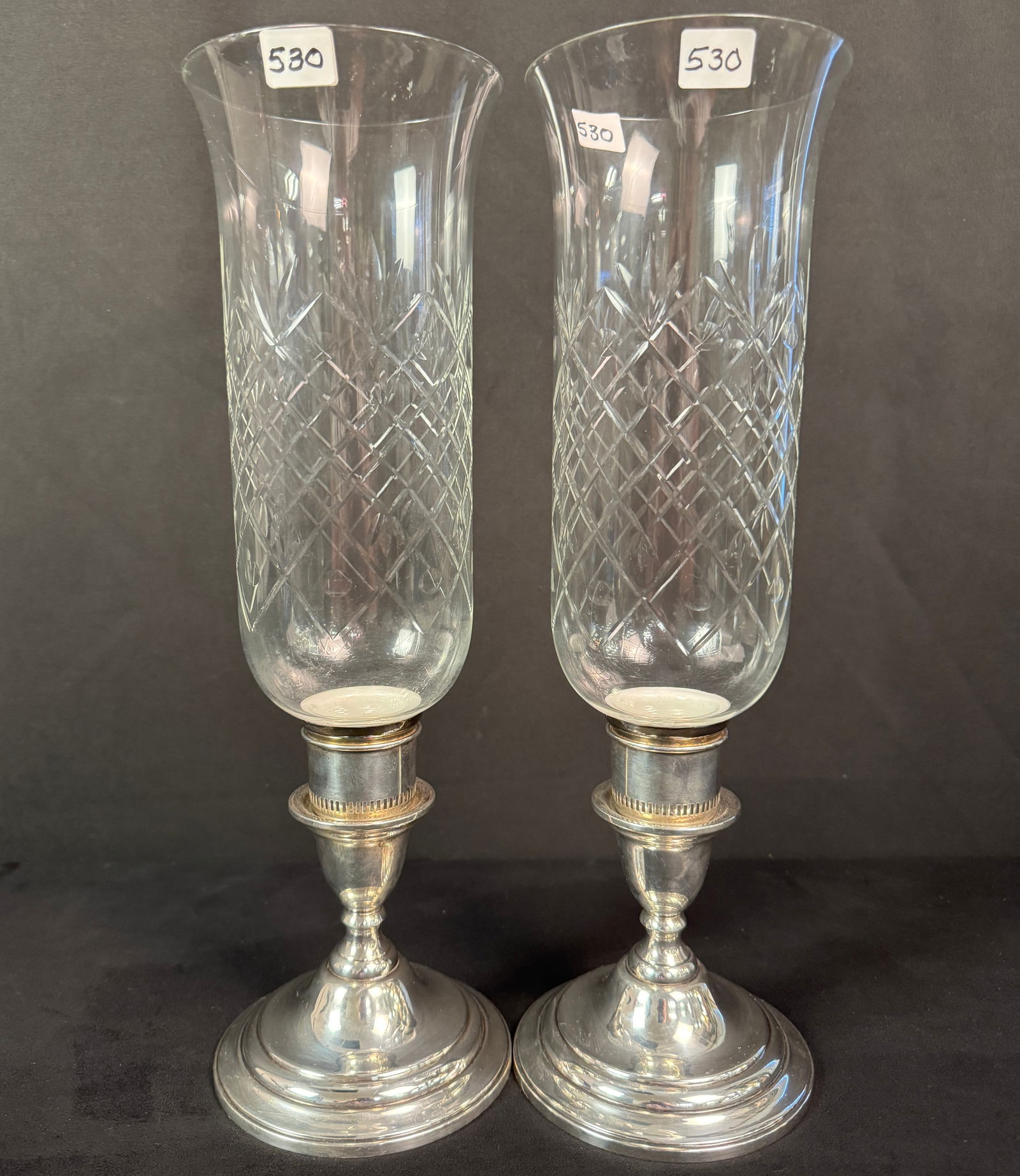 Sterling Weighted Hurricane Candle Lamps: A large pair of sterling weighted hurricane candle lamps with cut glass bell shades, in excellent house ready condition. This pair of weighted hurricane candle lamps measures 15" tall with shades, and