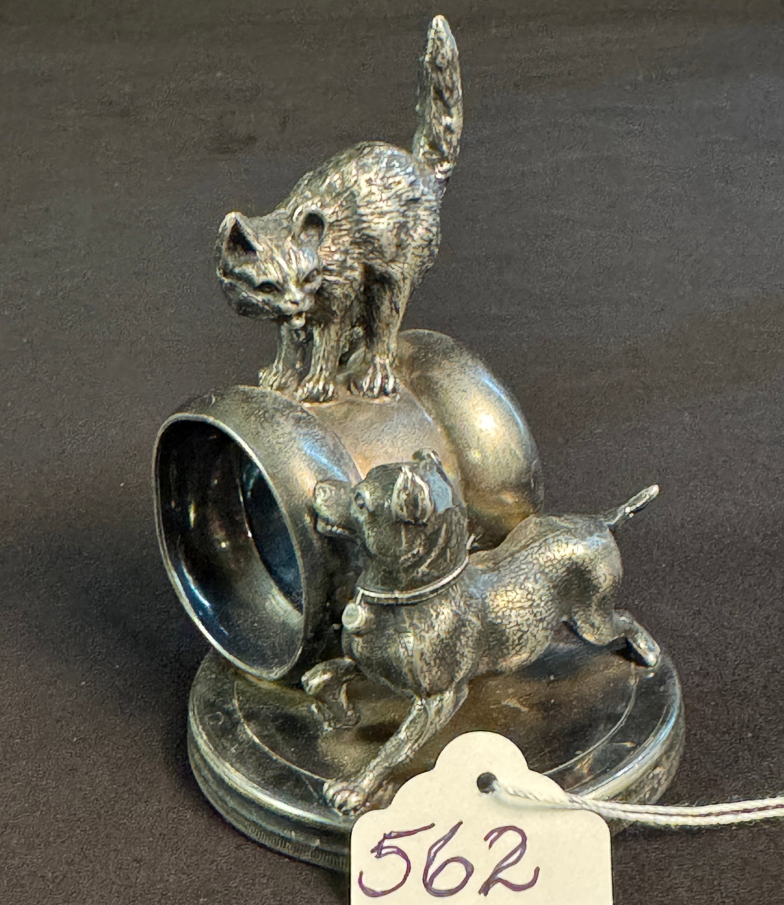 Figural Silverplate Napkin Ring of Dog and Cat: A figural silverplate napkin holder depicting dog and cat. Bottom is marked F.E. Rodgers Silver Company 1883 and measures 4.5" tall X 3" across".