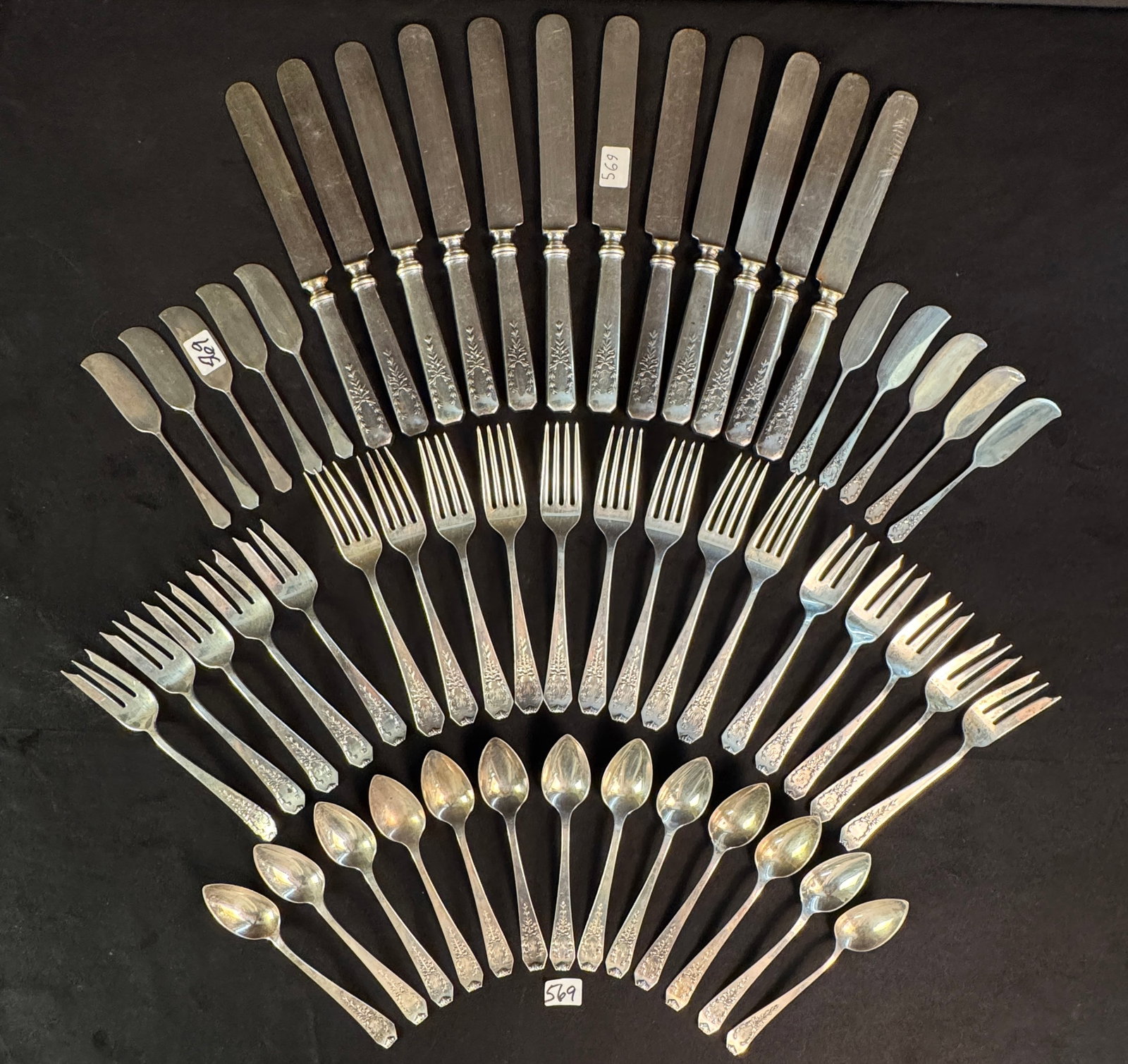 Edwardian Sterling Flatware Set: An Edwardian sterling silverware set with garland and wreath ornamentation around monogram. This set includes the following: 10 dessert forks (272.4 grams total), 9 dinner forks (376.47 grams total), 