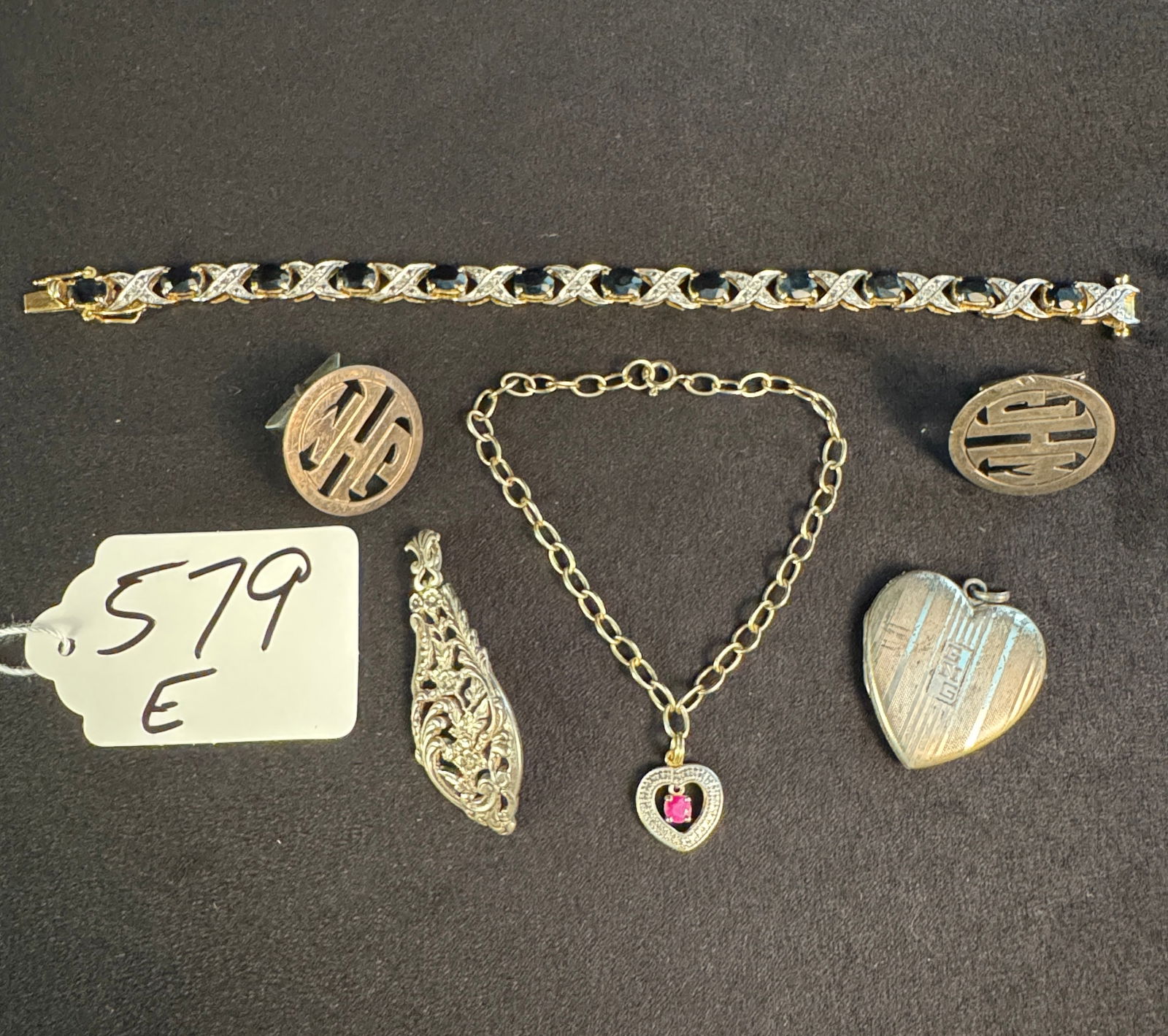Sterling Jewelry Lot to include Bracelets, Cuff Links and Pendants: A sterling jewelry lot to include a blue stone bracelet, a pair of Art Deco monogram cuff links, a heart charm bracelet, a heart locket dated 1944 and a filagree pendant. Total weight is 54.2 grams.