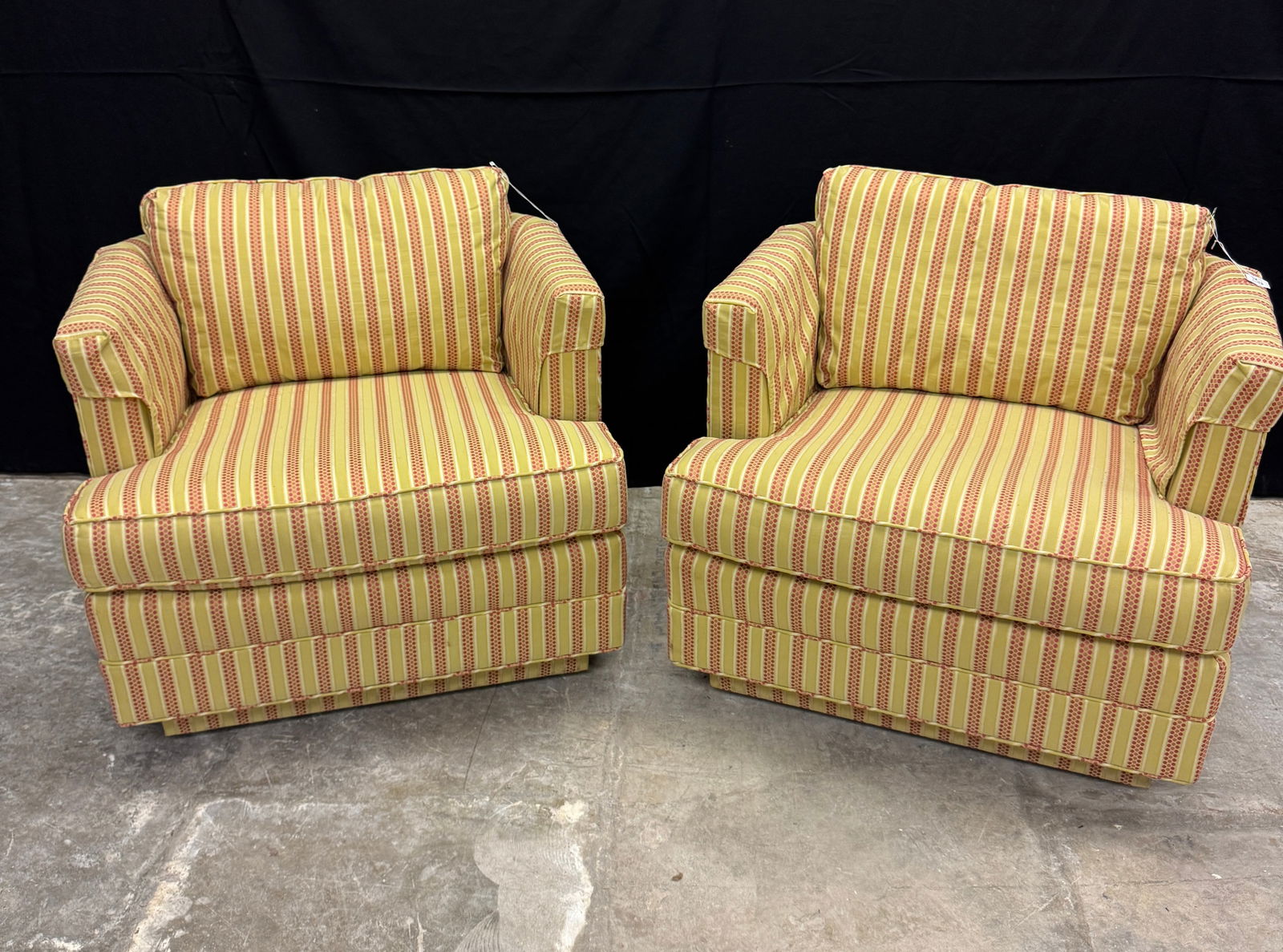 Pair of Mid Century Striped Swivel Club Chairs c1970's: A Mid Century pair of swivel base striped upholstery club chairs on casters with matching pillows in good condition. They each measure 31" X 31" X 31".