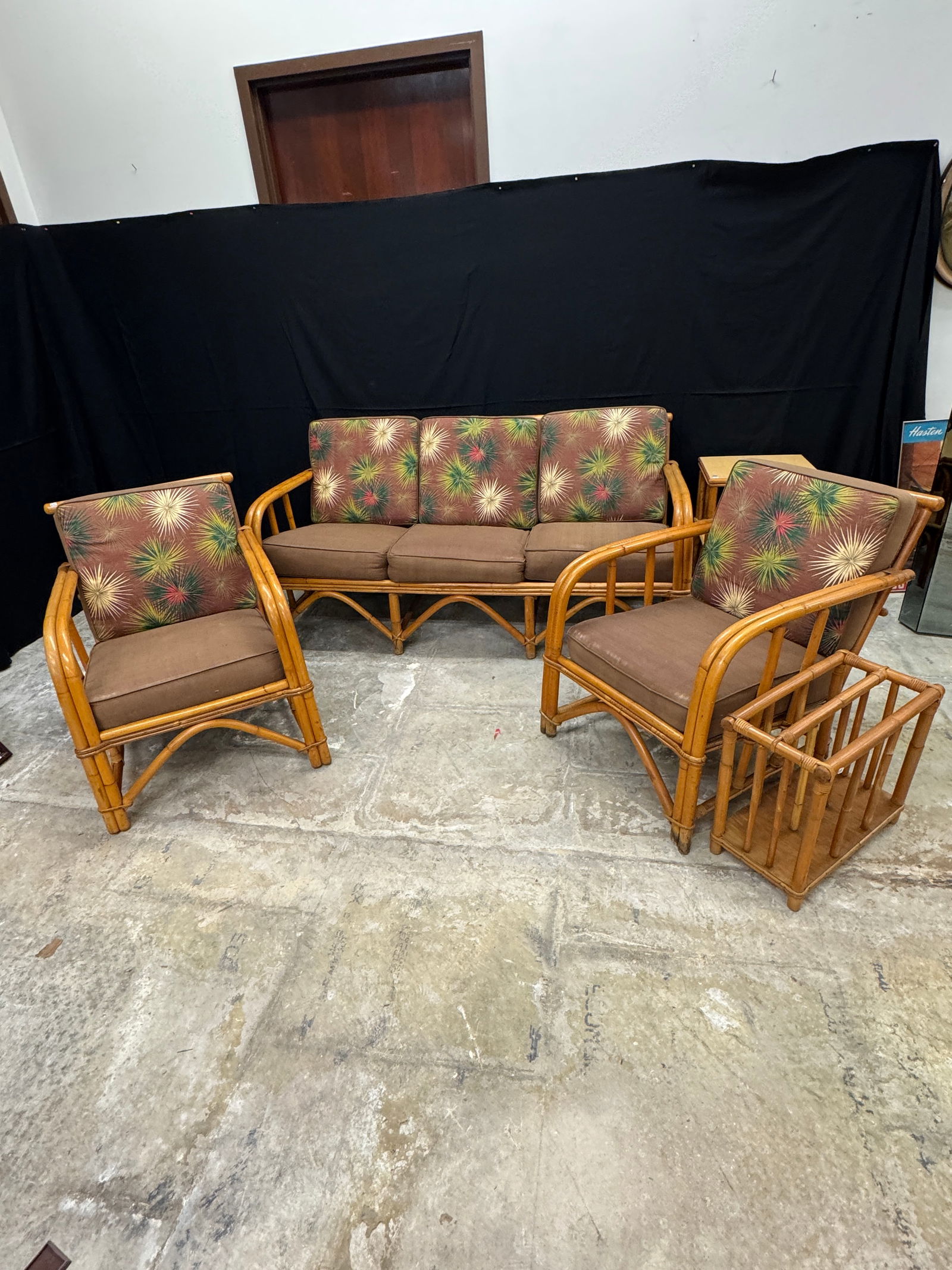 Rattan Sofa, Chairs and Table c1940's: A 1940's rattan parlor suite c.1940's from Klode Furniture to include a sofa, 2 matching armchairs, two tiered side table, and magazine rack, all with original graphic bark cloth upholstery in very go
