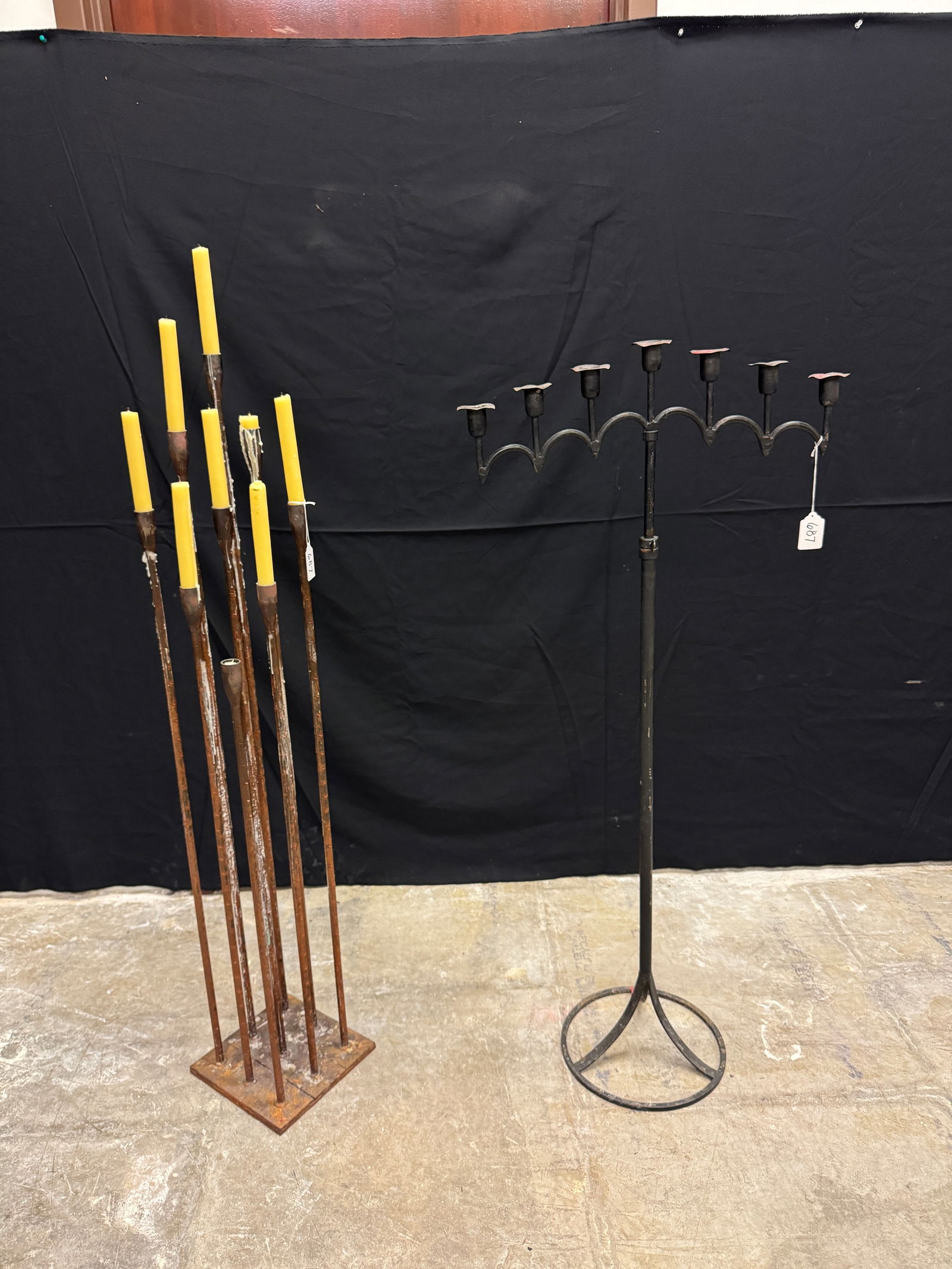 2 Iron Floor Standing Candle Holders: 2 Mid Century iron floor standing candelabras to include a 9 candle Brutalist Candelabra in the style of Harry Bertoia with a rustic finish that measures 47" tall, and a 7 candle black iron height adj