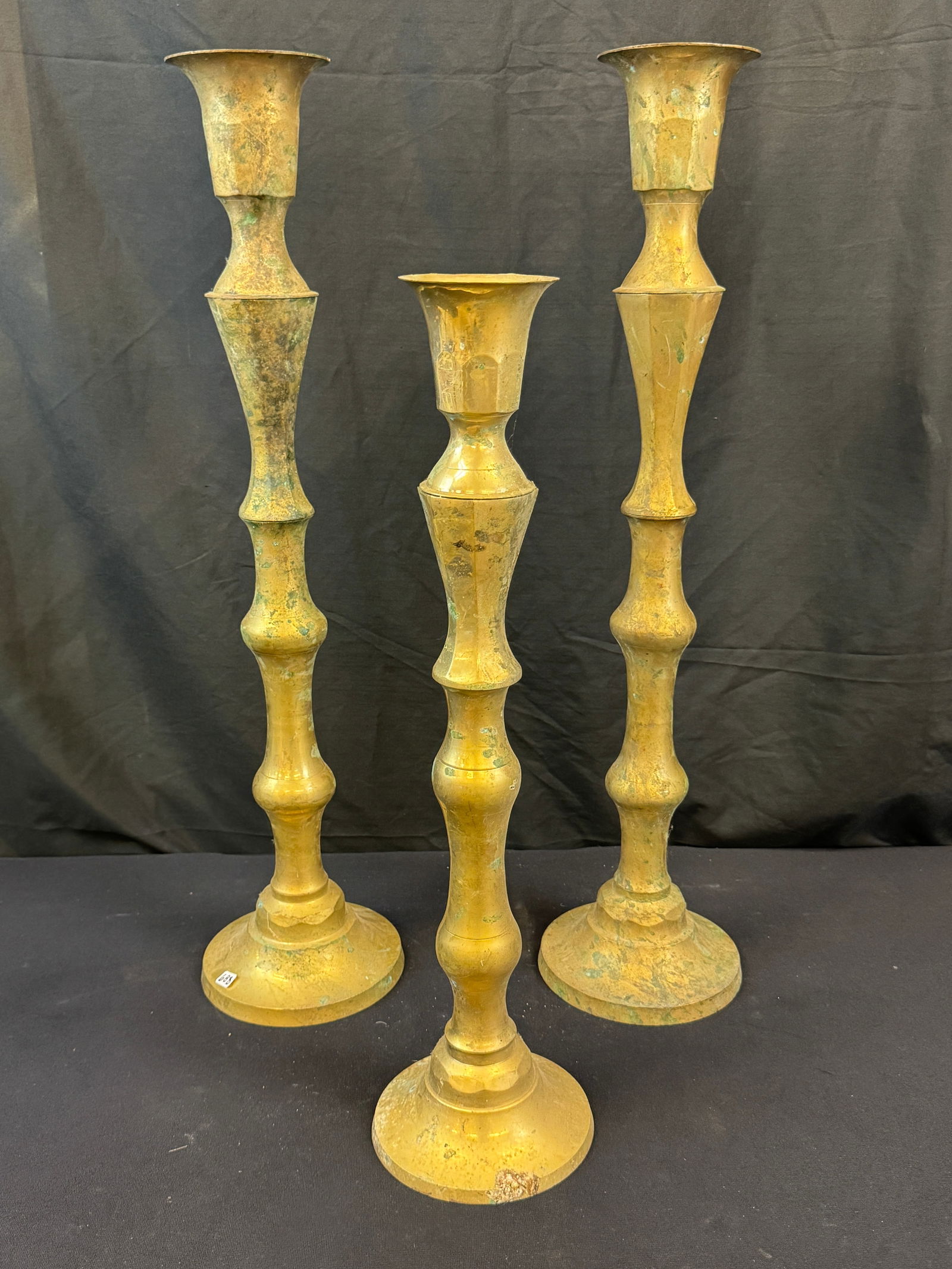 3 Mid Century Brass Candle Holders c1960's: 3 Mid Century Brass Candle Holders. One is a matching pair that measures 29" tall X 6.5" across the base, and a shorter version that measures 23.5" tall. Need cleaning, but in good condition.