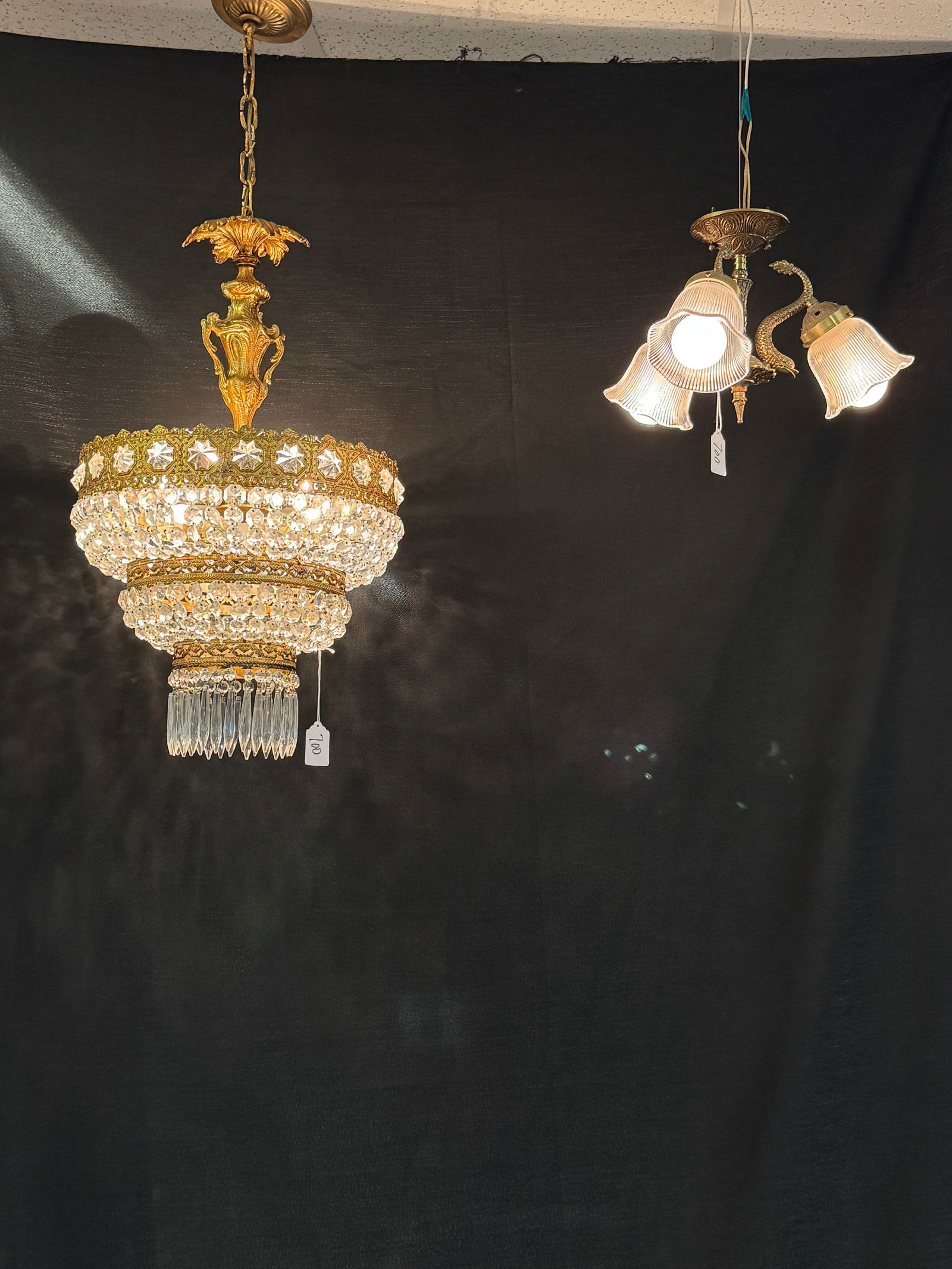 Hollywood Regency Crystal Chandelier & Dolphin 3 Light Ceiling Fixture: Two Mid Century Hollywood Regency light fixtures c1950's to include a fancy brass 3 tiered crystal chandelier in good condition (27" tall x 14" across), and a flush mount fancy brass 3 light fixture w