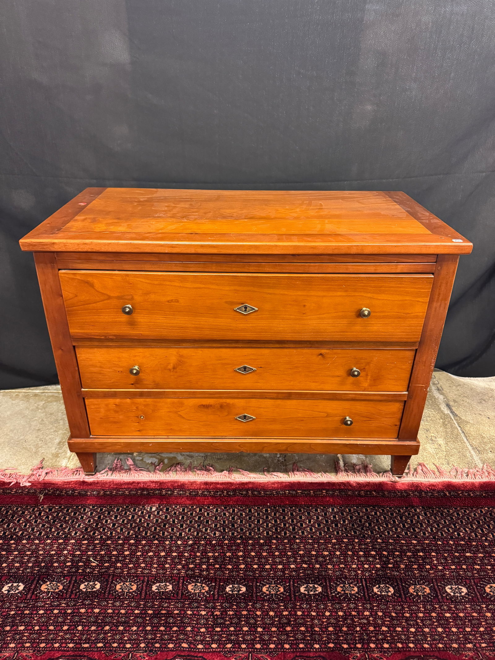 Richelieu 3 Drawer Commode: A Richelieu 3 drawer French made commode in cherry. Features round brass pulls (one is missing), pegged construction, dovetailed drawers and brass capped feet. It measures 28" tall X 27" across X 19.5