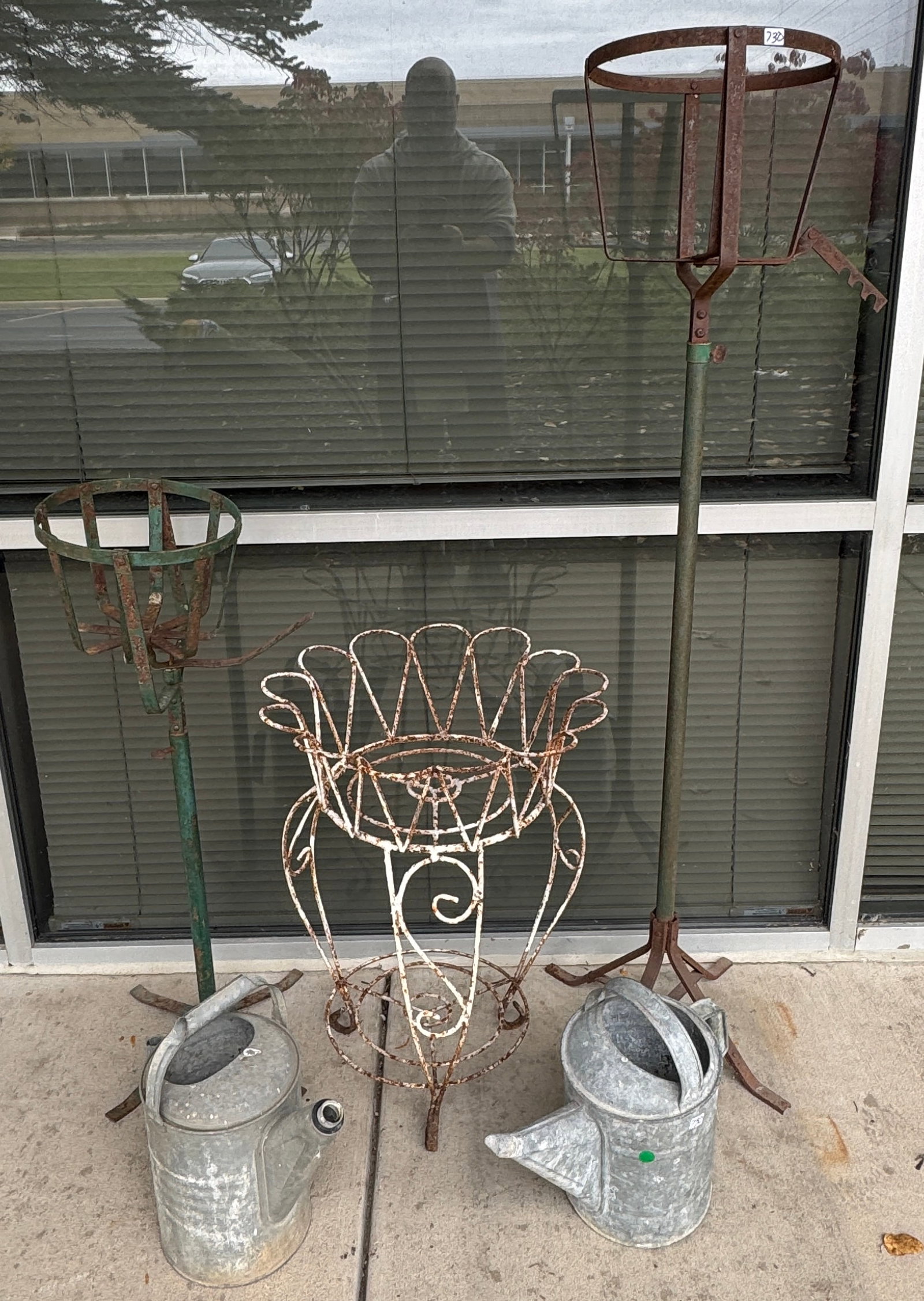 Iron garden planters: Pair of iron plant holders, a wire plant holder & 2 watering cans.