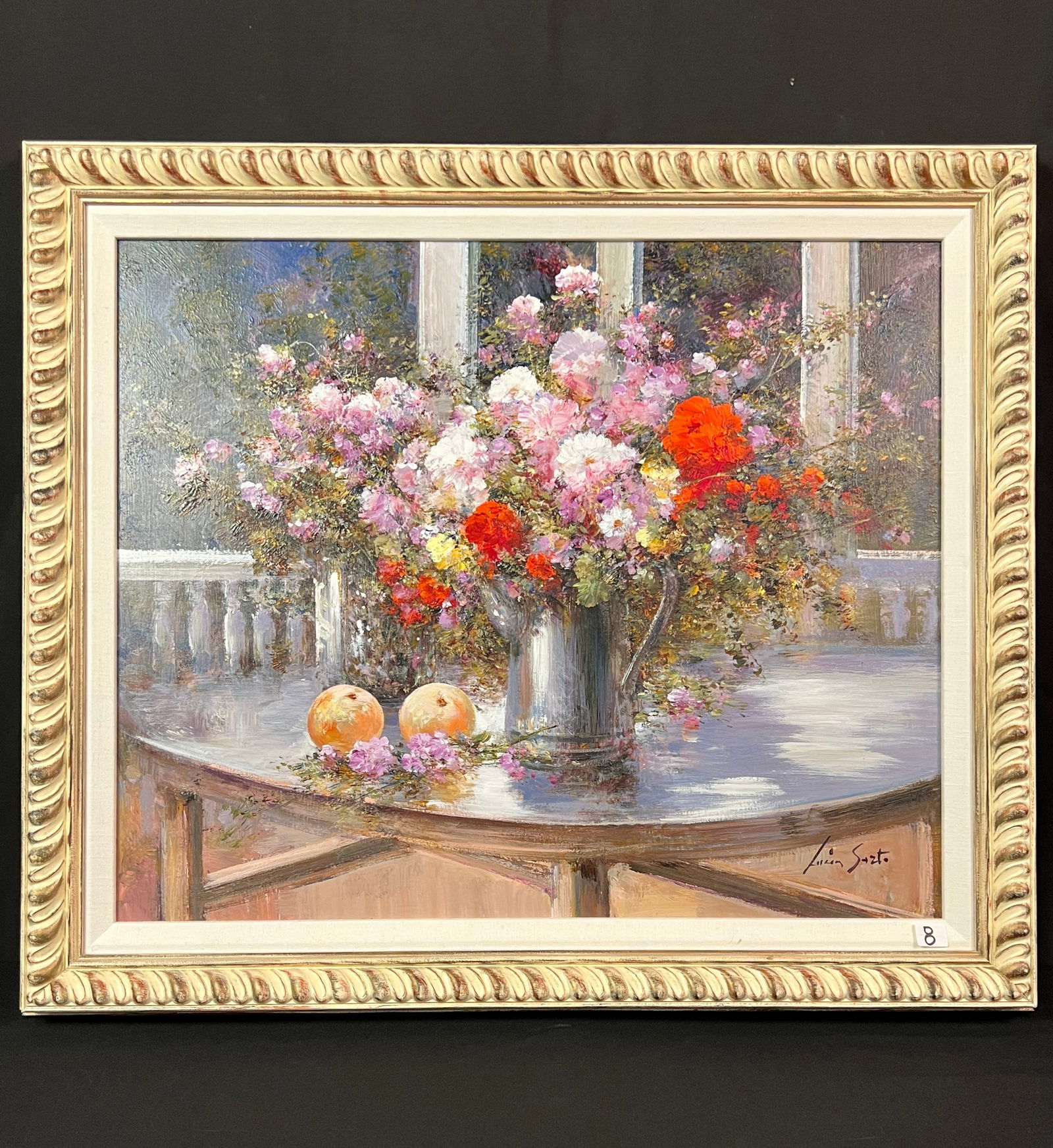 Lucia Sarto Oil on Canvas: This quality framed oil on canvas Realist still life of flowers is by listed Italian artist Lucia Sarto (1950- ).It features a vase of roses on a table on a porch with fruit. In Excellent Condition.