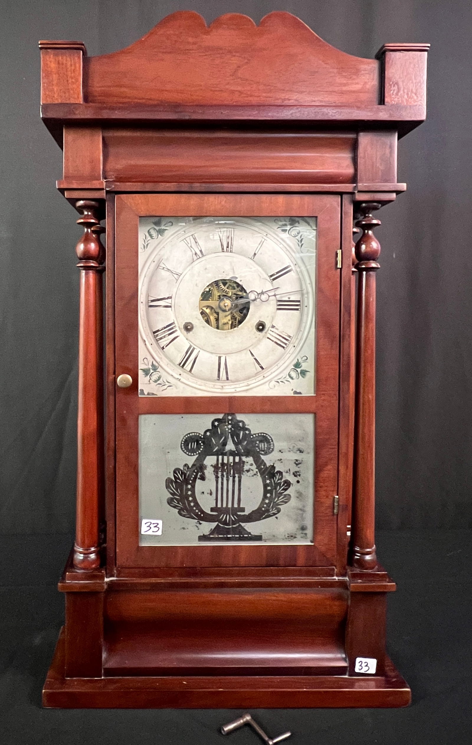 Seth Thomas Wood Cased Clock C.1820's: A Seth Thomas hand painted weight driven, tin faced shelf clock with a back painted lower door that features a lyre. It has an open escapement in a 4 pillared mahogany case c1820's. Face features hand