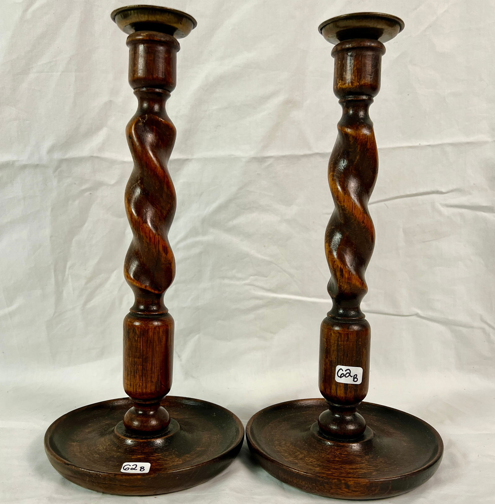 Pair of 18th Century English Candlesticks: A pair of 18th century English candlesticks with brass wax catchers and barley twist shape. In excellent condition, they measure 12.5" tall.