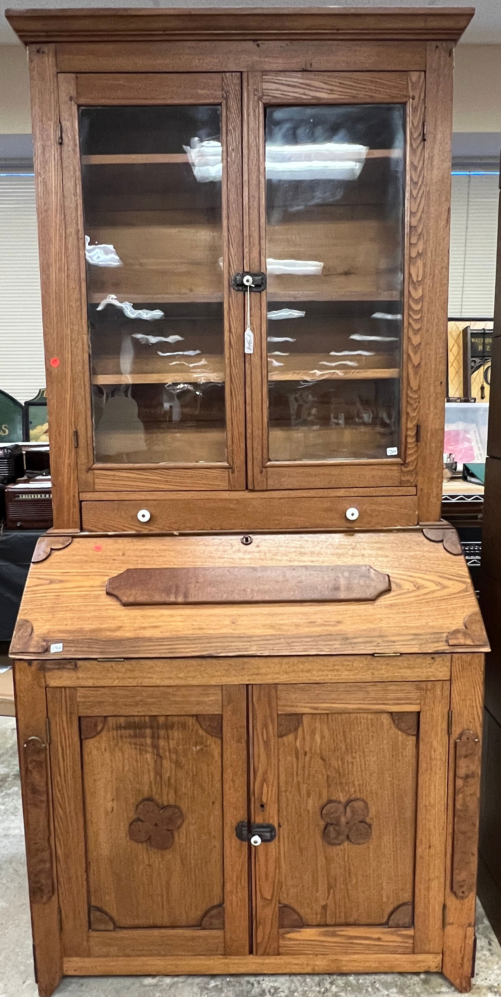 Early Oak Drop Front Secretary c1850's: An American antique drop front secretary that features double door glass bookcase top with original glass, iron locks, original hinges, porcelain knobs on upper drawer, fitted interior, and folk art c
