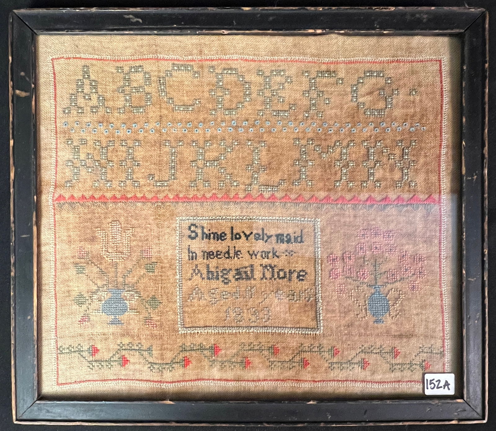 Antique American Child's Sampler c1833: An antique American child's sampler dated 1833 by Abigail More, aged 11 years that features cross stitched alphabet, floral border along bottom, multipole colors, and two vases full of floral bouquets