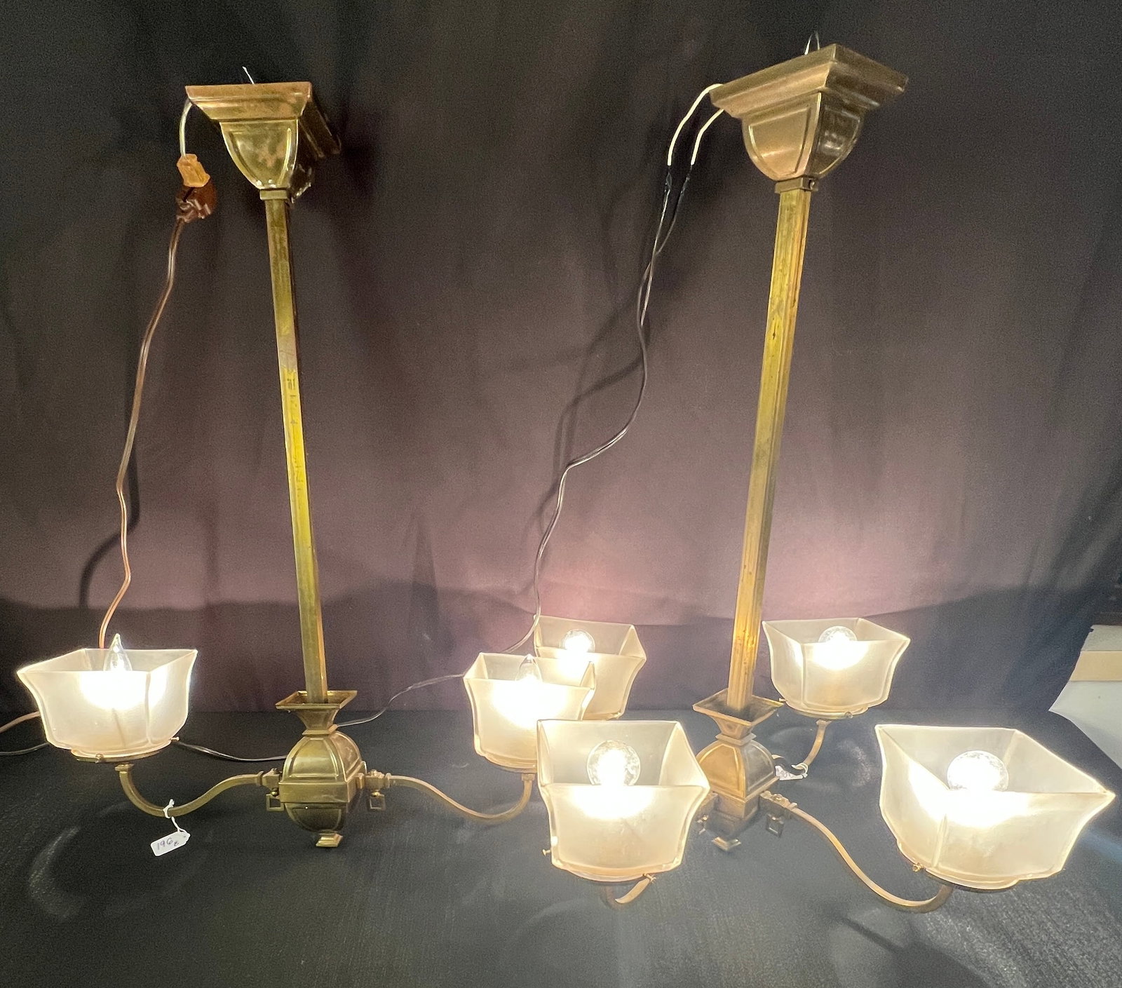 2 Vintage Brass Chandeliers: Vintage brass gas fixtures with frosted glass square shades. They have been electrified. The first has 4 arms and the second has 2 arms. In as found condition, they measure 30" tall X 24" across.