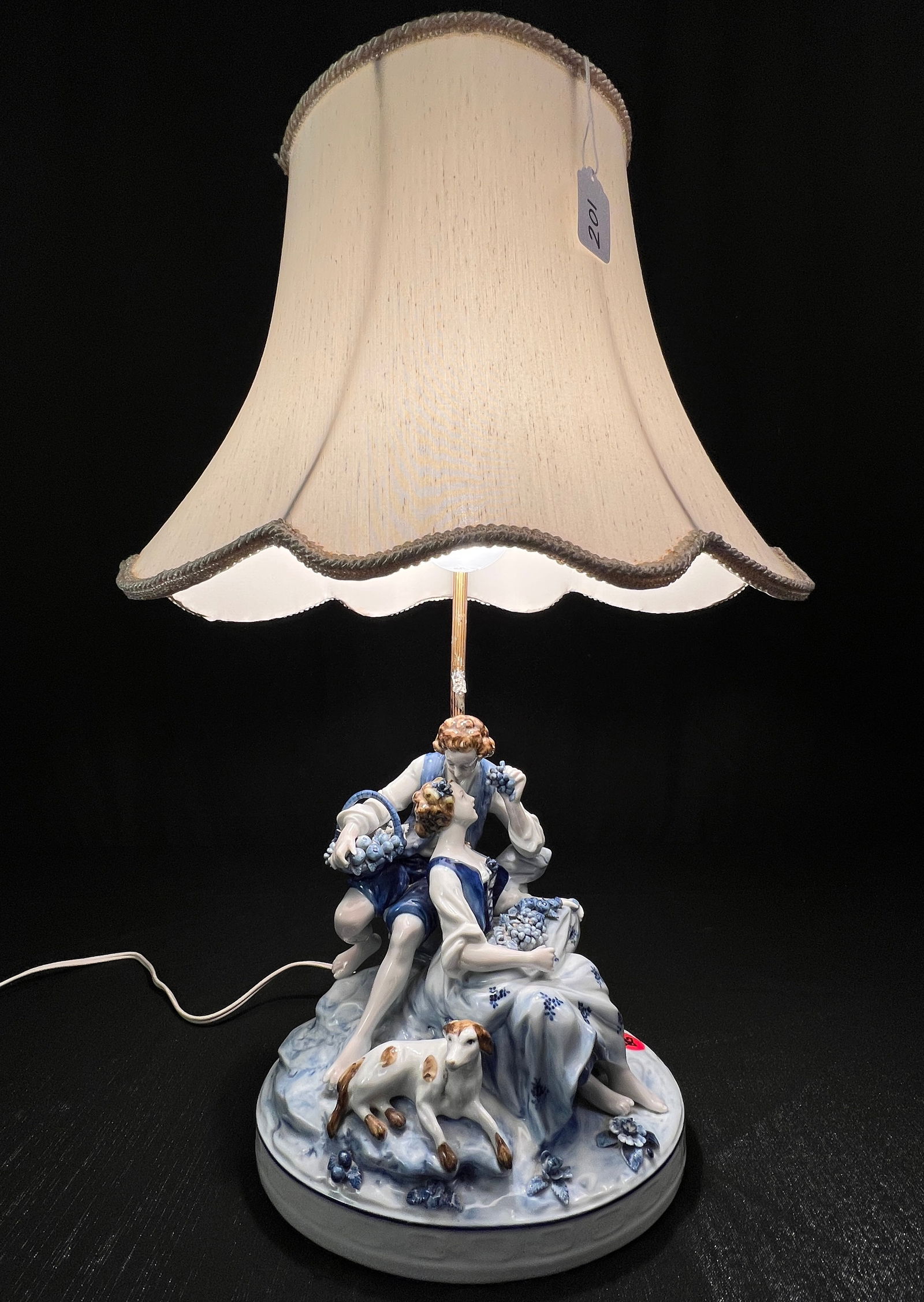 Dresden Style German Figural Lamp C1900: A Dresden style German Porcelain figural lamp c 1900 depicting a young couple eating grapes with their dog in excellent condition. It is marked made in Germany on the bottom. It measures 22" tall X