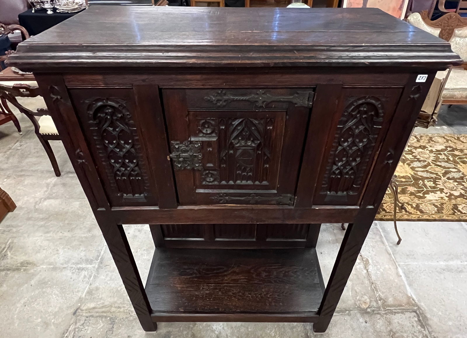 Tudor Single Door Cabinet C.1890's: An English oak elaborately carved Tudor single door cabinet that features hand wrought fancy hardware, all peg construction, linen fold sides and back panel and original finish. It measures 53" tall