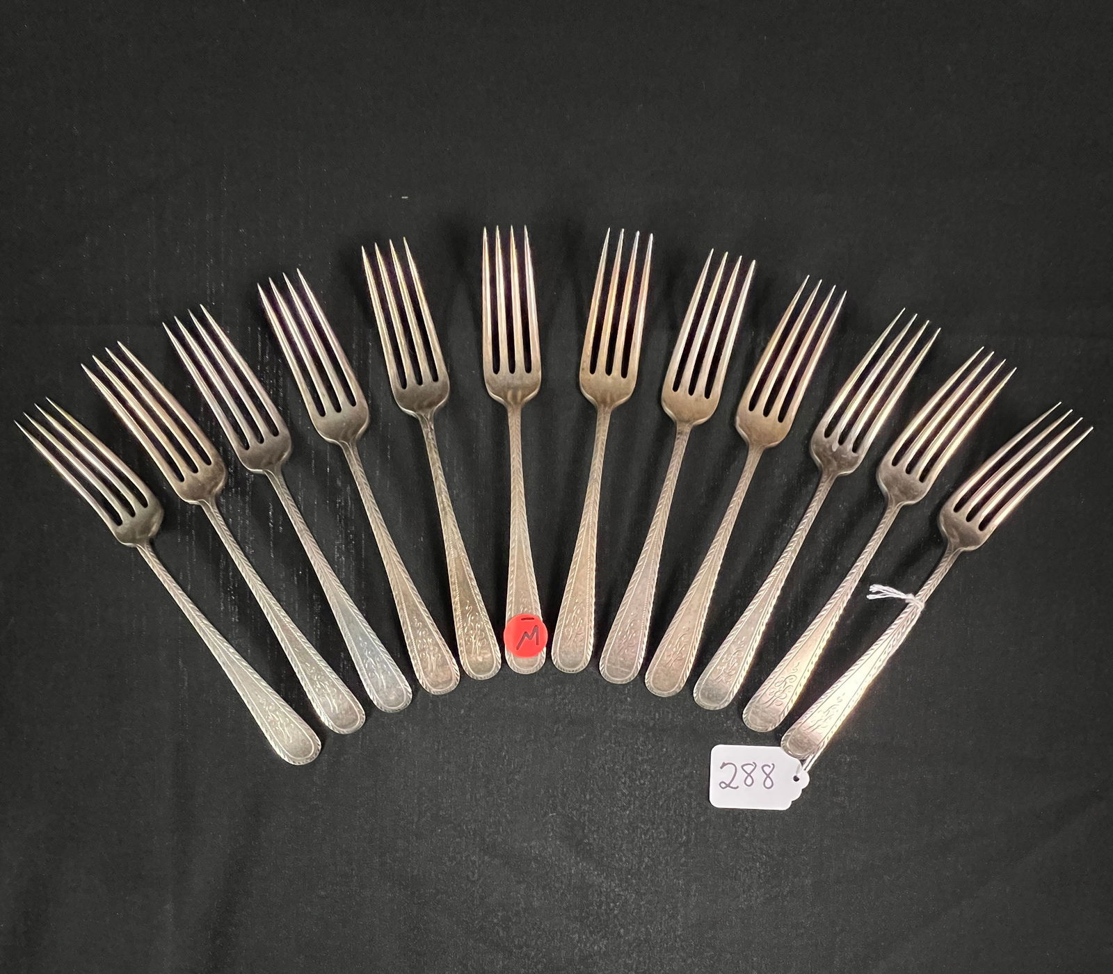 12 Sterling Silver Dinner Forks: 12 sterling silver Theodore B. Starr dinner forks, c1900-20, weighing in at 606g. They are detailed with a feathering design and monogram.