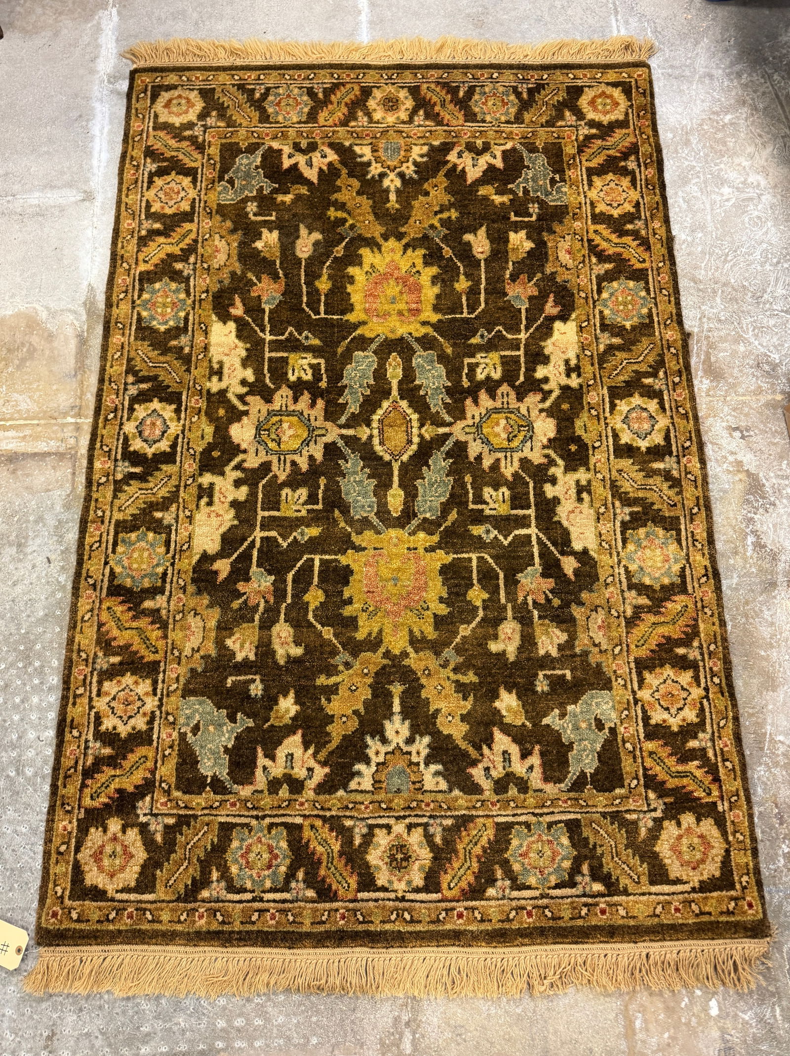 Middle Eastern Hand Tied Floral Geometric Rug: A Middle Eastern hand tied floral geometric rug in browns, creams, blues and reds. It measures 73" long X 48" across.