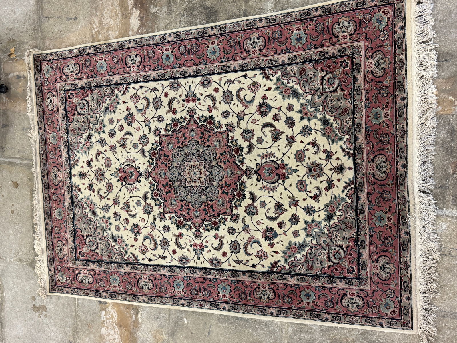 Tabriz Persian Wool Silk Hand Tied Rug: A Tabriz Persian silk and wool hand tied rug that features 3 floral borders, center mandala on a floral field in creams, greys, pinks, navy and greens. In excellent condition it measures 79" long X 55