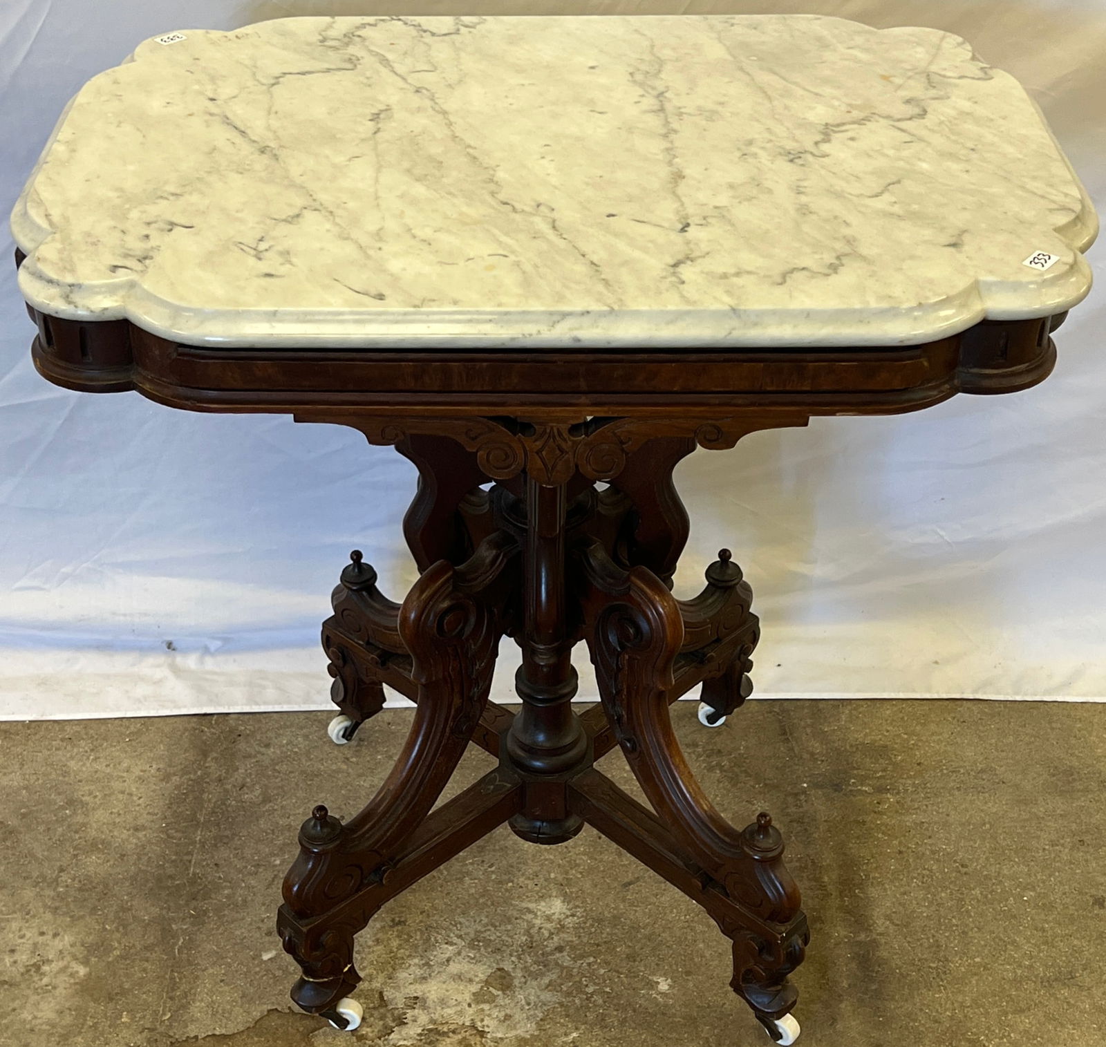 Renaissance Marble Top Table: A quality Victorian Renaissance Revival marble top parlor table with burled panels, deep floral carvings, and finial trims. In original finish with a white marble turtle top. In excellent condition,