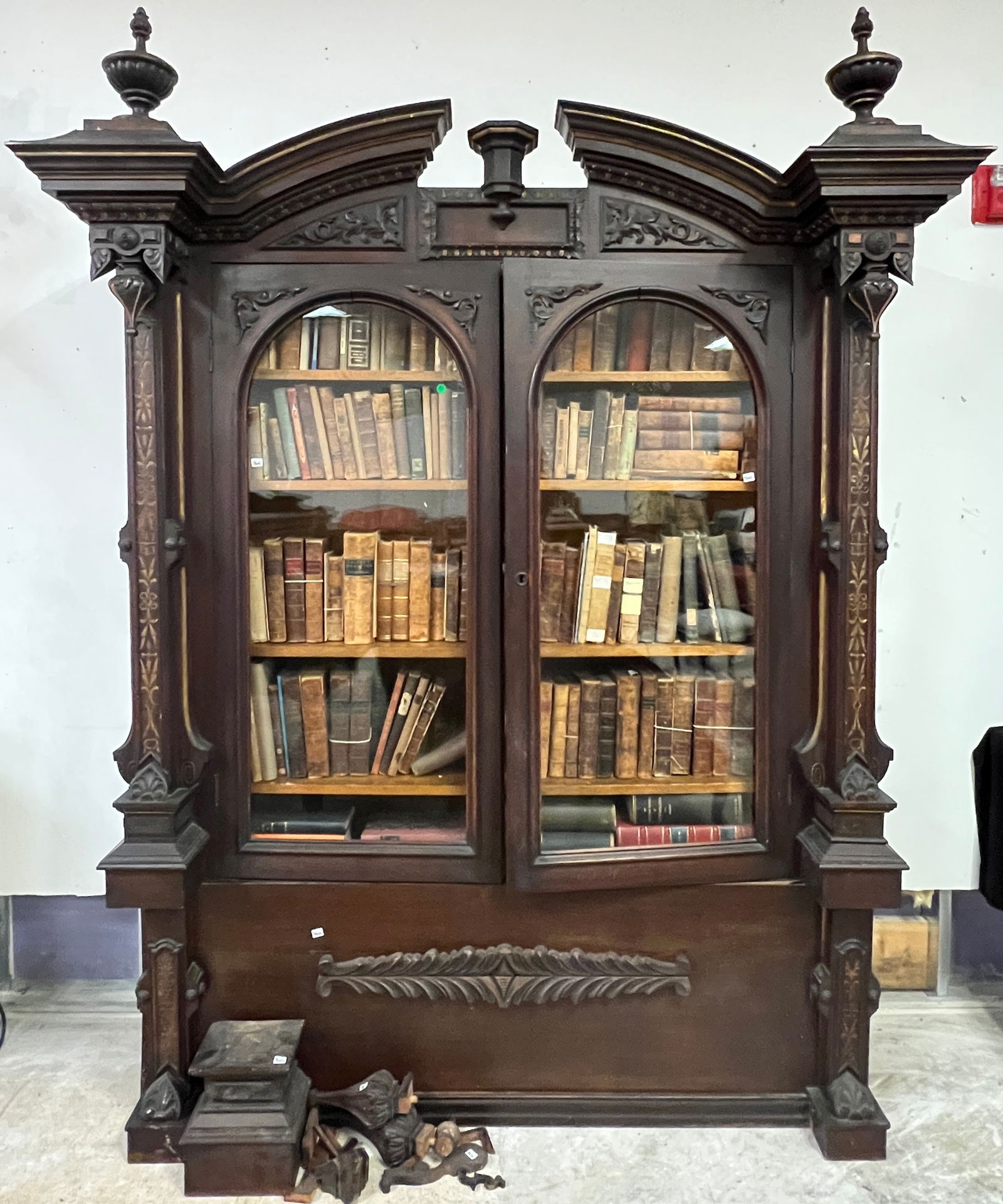 Walnut Victorian Renaissance Double Door Bookcase: An impressive Renaissance Revival double door bookcase, that matches the mantel mirror (lot 361) and probably were featured together in room. This bookcase has an arched pediment, turned finials, in b