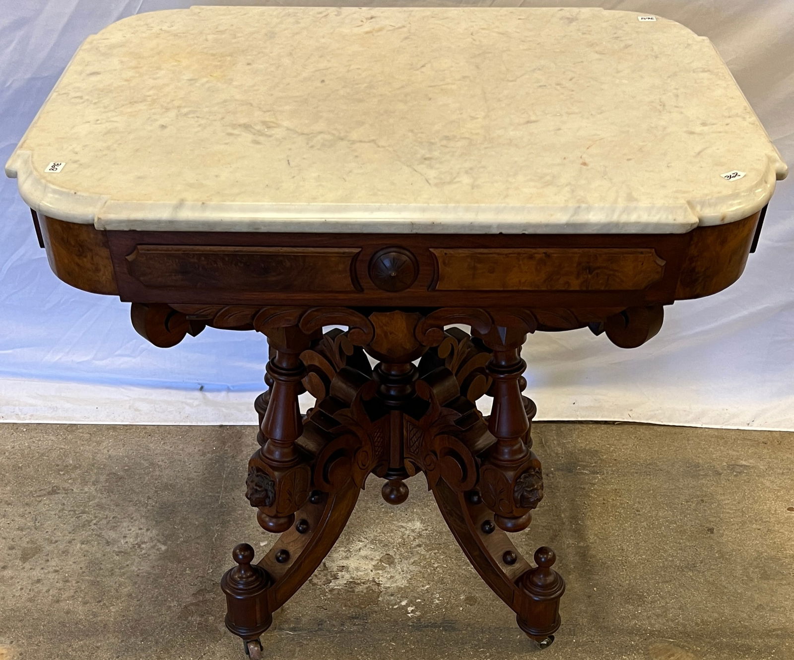 Renaissance Revival Marble Top Table: A stunning, elaborate Renaissance Revival turtle marble top parlor table, with turn post and ball decorations, burled panels, lions heads and spindled base. This over the top marble top parlor table
