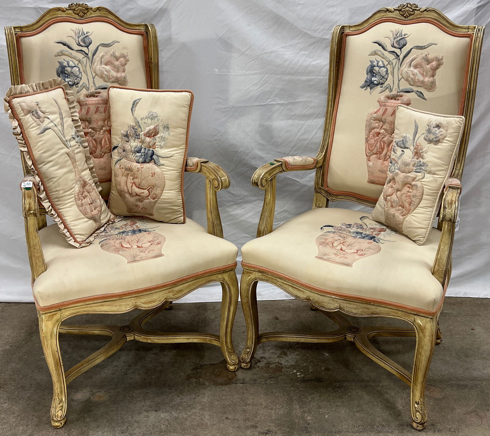 Pair of 1950s/60s Country French Armchairs: A pair of late 1950s/early 1960s Country French winged, hand carved armchairs with quilted upholstery depicting raised vases. They come with matching quilted and ruffled pillows. These Country French