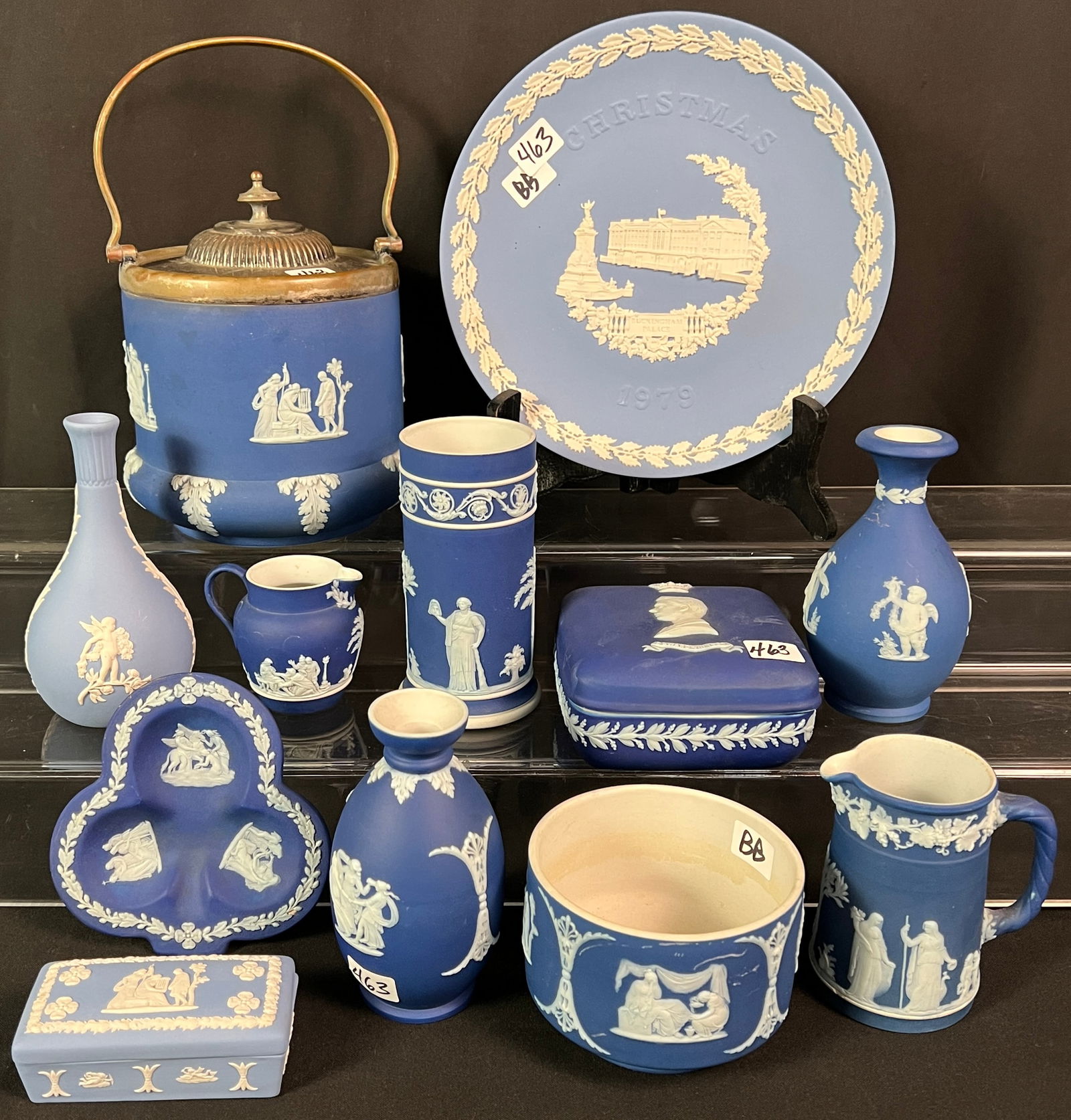 12 Pieces of Blue Wedgewood: A group of 12 blue Wedgewood pieces to include a covered biscuit jar depicting Greek gods, a dark blue vase depicting Greek gods, a covered cigarette holder depicting Prince Edward, a powder blue