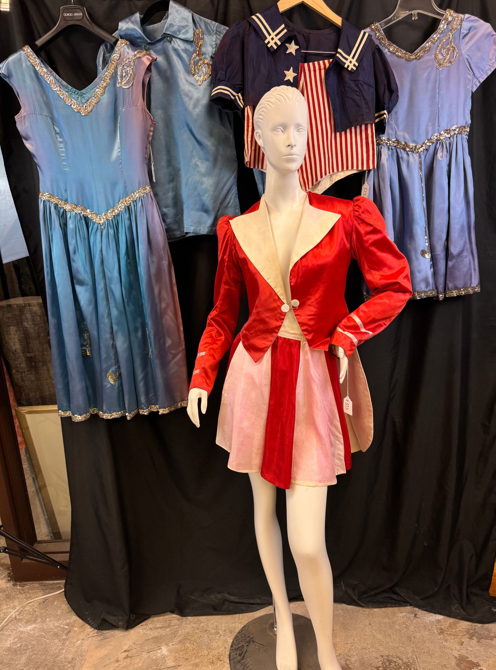 Vintage Group of Baton Twirler Outfits c1940's: A vintage group of baton twirler outfits c 1940's to include a red satin tailcoat, bib, and red and white striped short skirt, a blue satin dress with flair knee length skirt and silver sequin detaili