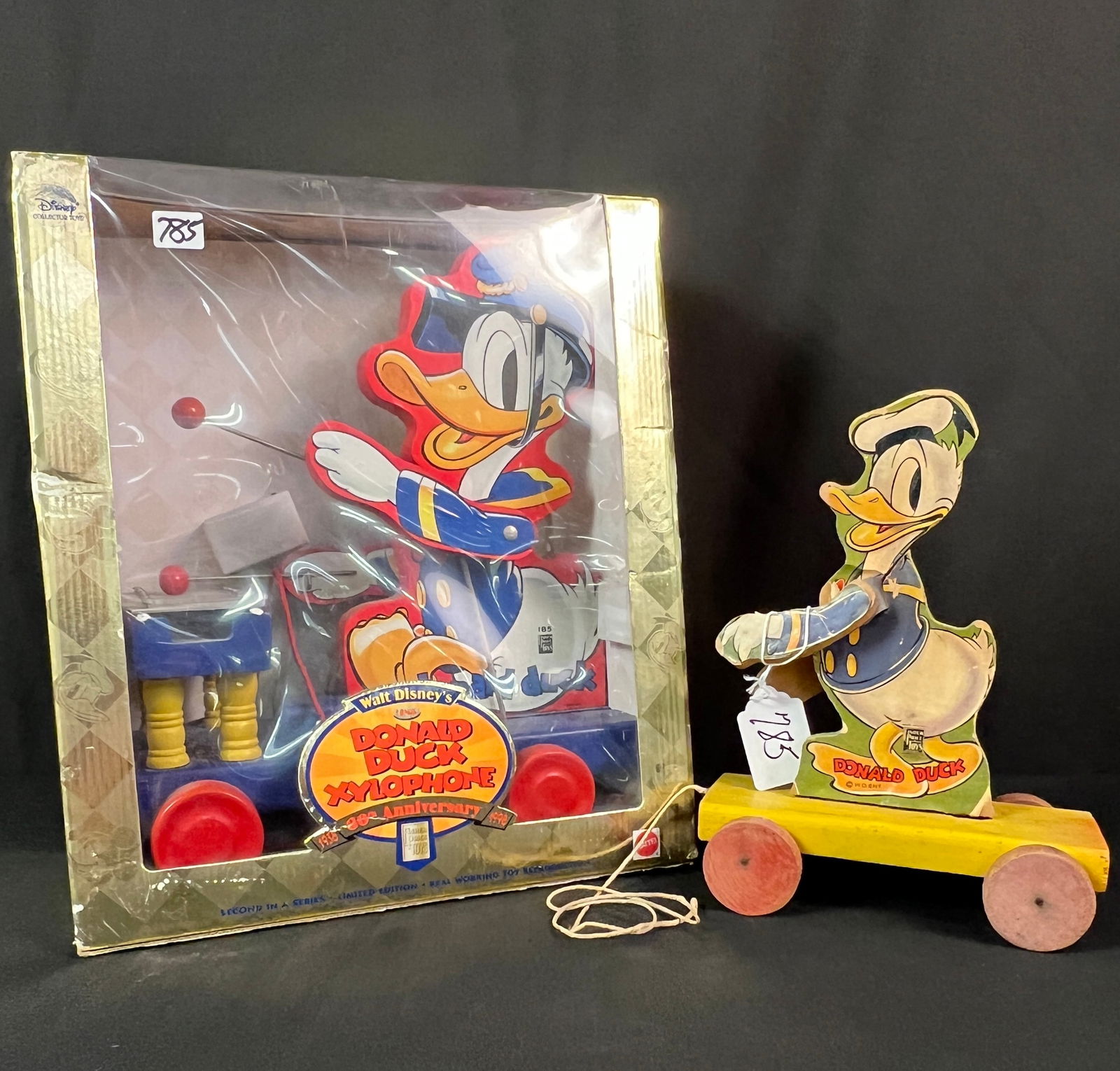 Original Donald Duck Pull Toy Along with a Reproduction: An antique original wooden Donald Duck pull toy in fair condition. Along with a brand new, still in the box, Donald Duck on xylophone wooden pull toy.