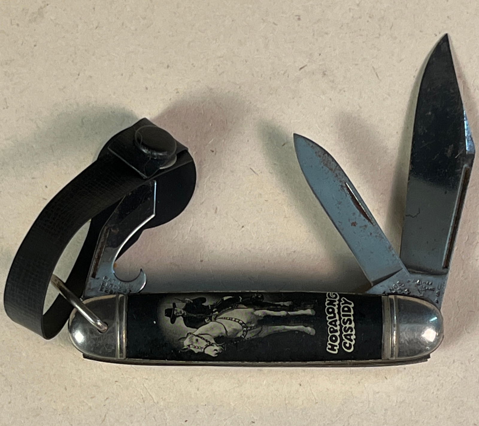Hopalong Cassidy Pocket Knife: A vintage 1950s Hopalong Cassidy pocket knife and lanyard. A popular piece of memoribilia, it features Hoppy on his horse with his name underneath. In great condition it measures 3.5" long.