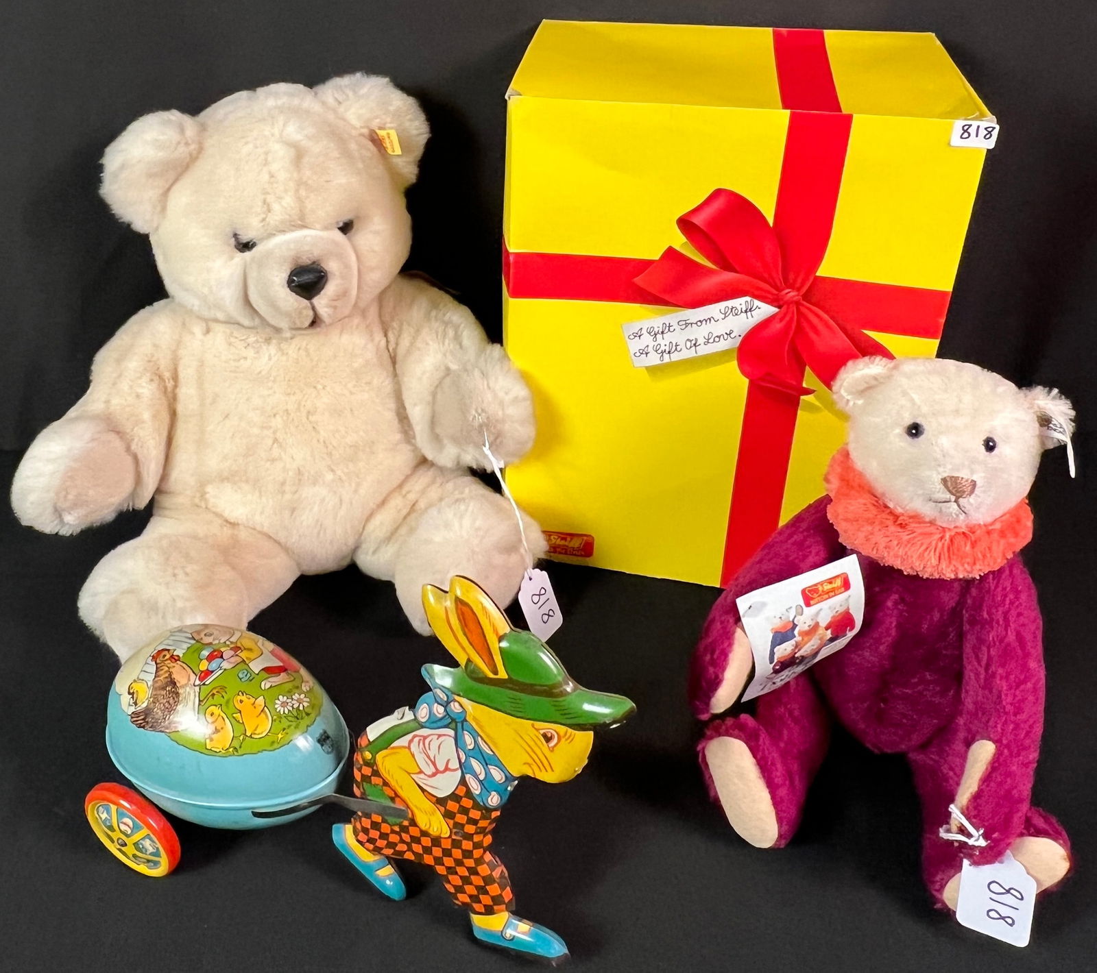 Two Steiff Stuffed Animals and Vintage Tin Litho Easter Toy: A group to include a Steiff Circus Dolly Bear replica of a 1913 stuffed animal with tag, a Steiff stuffed bear with brown ribbon and original box, and a vintage tin litho Easter bunny toy carting an e