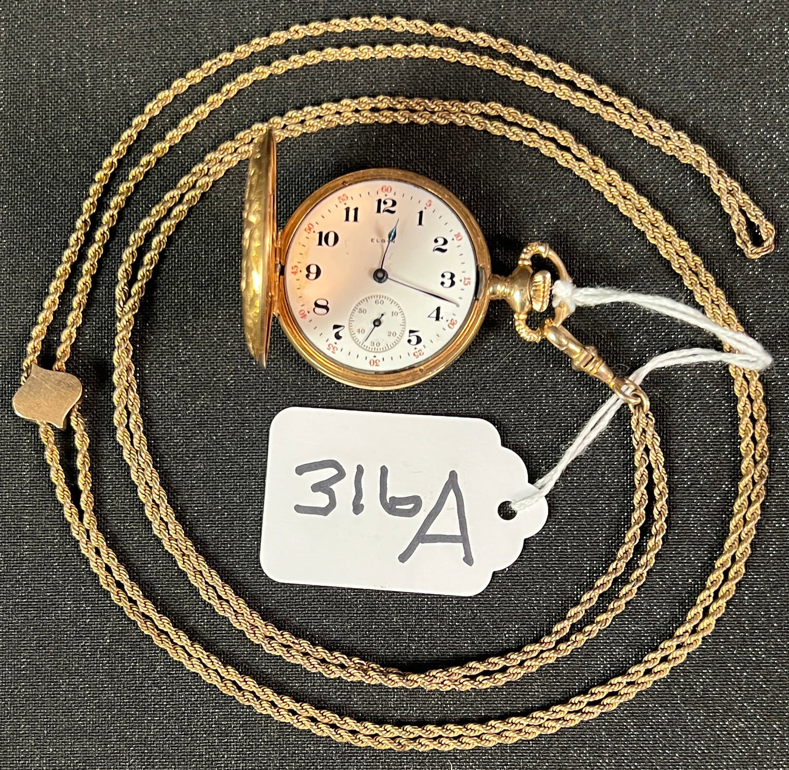14K Gold Ladies Pocket Watch: A 14k gold ladies pocket watch by Elgin, watch is missing glass and front cover does not stay closed. Watch features elaborate filagree design, inside of watch is marked 14K. Chain and slide charm