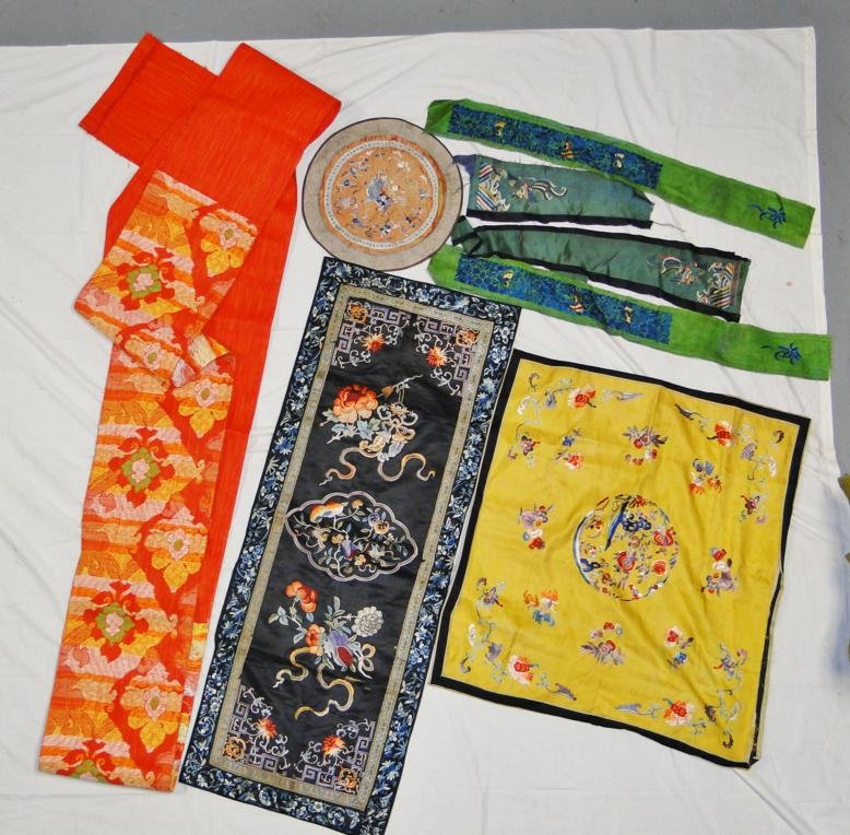 A large oriental embroidered runner depicting flowers a: A large oriental embroidered runner depicting flowers and birds along with a table throw depicting flowers and birds, 2 robe remnants depicting butterflies, an oval table mat depicting a dragon and ch
