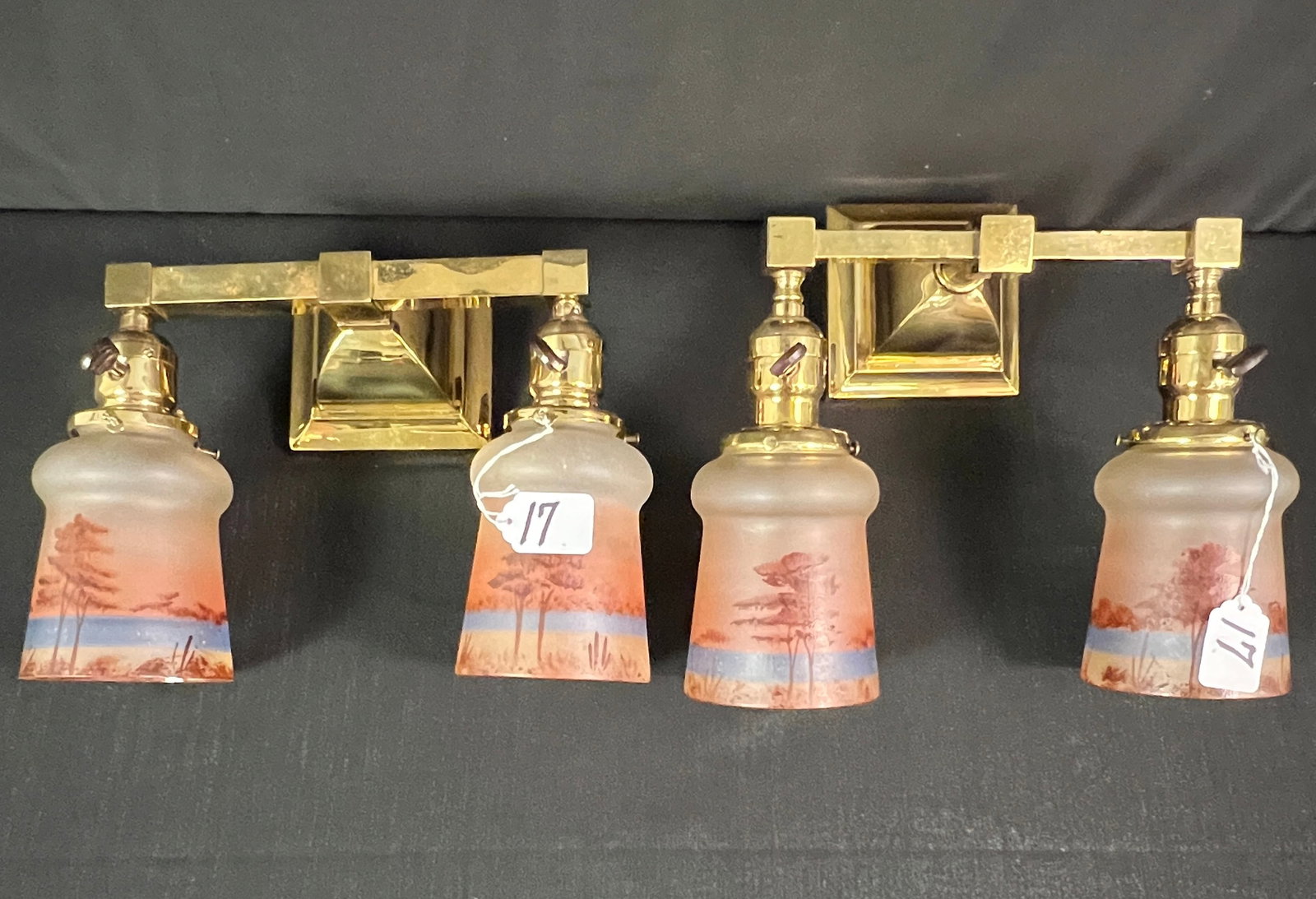 Pair of Brass Mission Double Armed Wall Sconces: Pair of brass mission double armed wall sconces professionally polished, with four reverse painted shades depicting woodland scenes. Sconces measure 9" tall by 9" across each. Shades measure 5" tall.