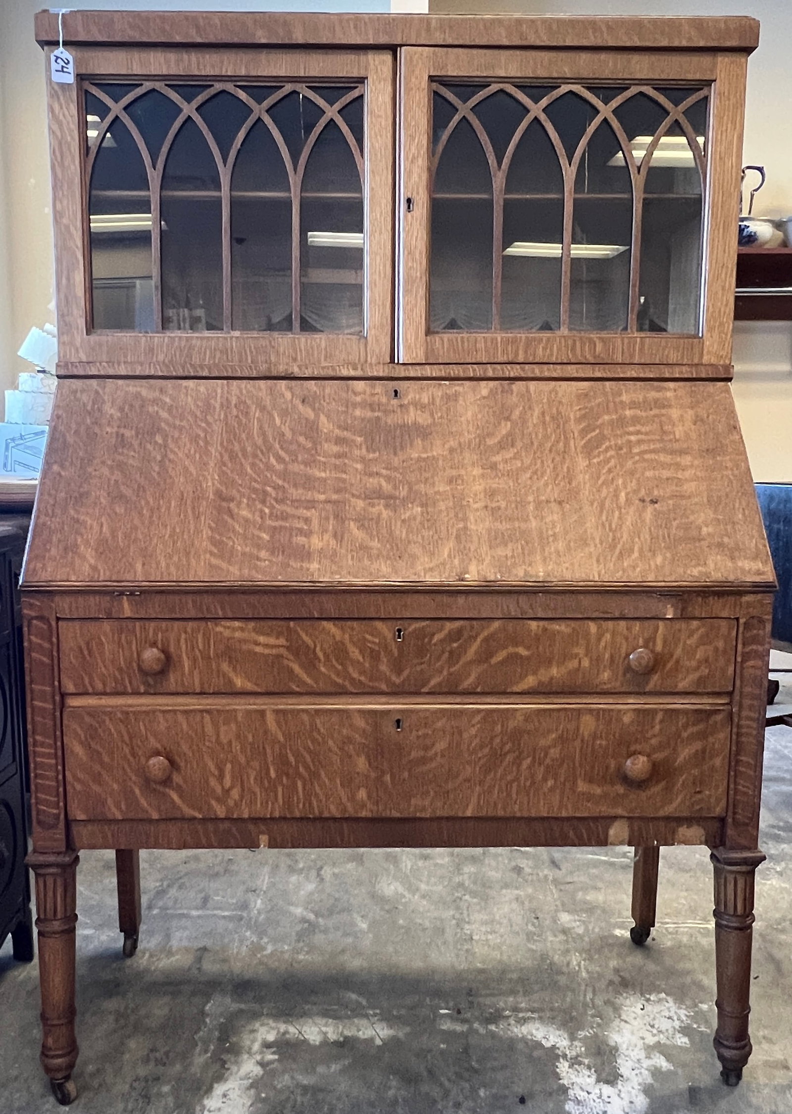 Mission Oak Drop Front Desk with Book Case Top: A mission oak drop front desk with a book case top, double drawer base and fitted interior. It is in original finish and measures 59" tall X 38" across X 17" deep.