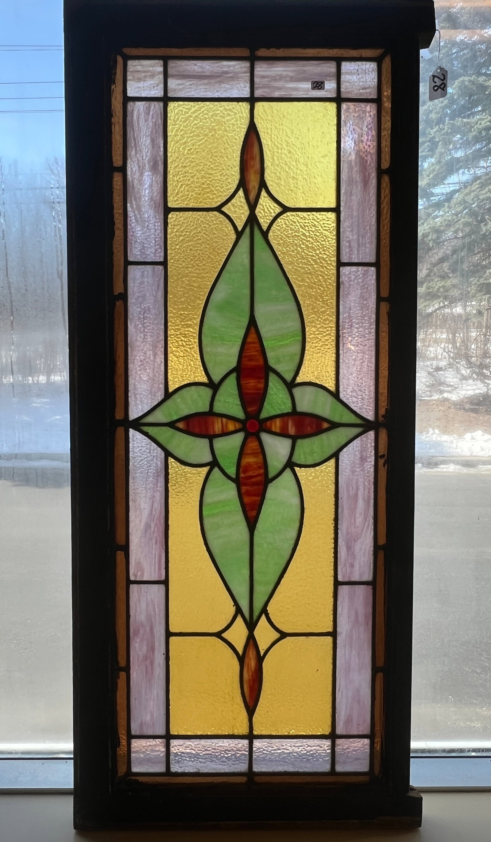Stained Glass Transom Window: An antique stained glass transom window with jeweled ruby center, lavender slag glass border and green floral design. In excellent condition, it measures 19" tall X 46" across.