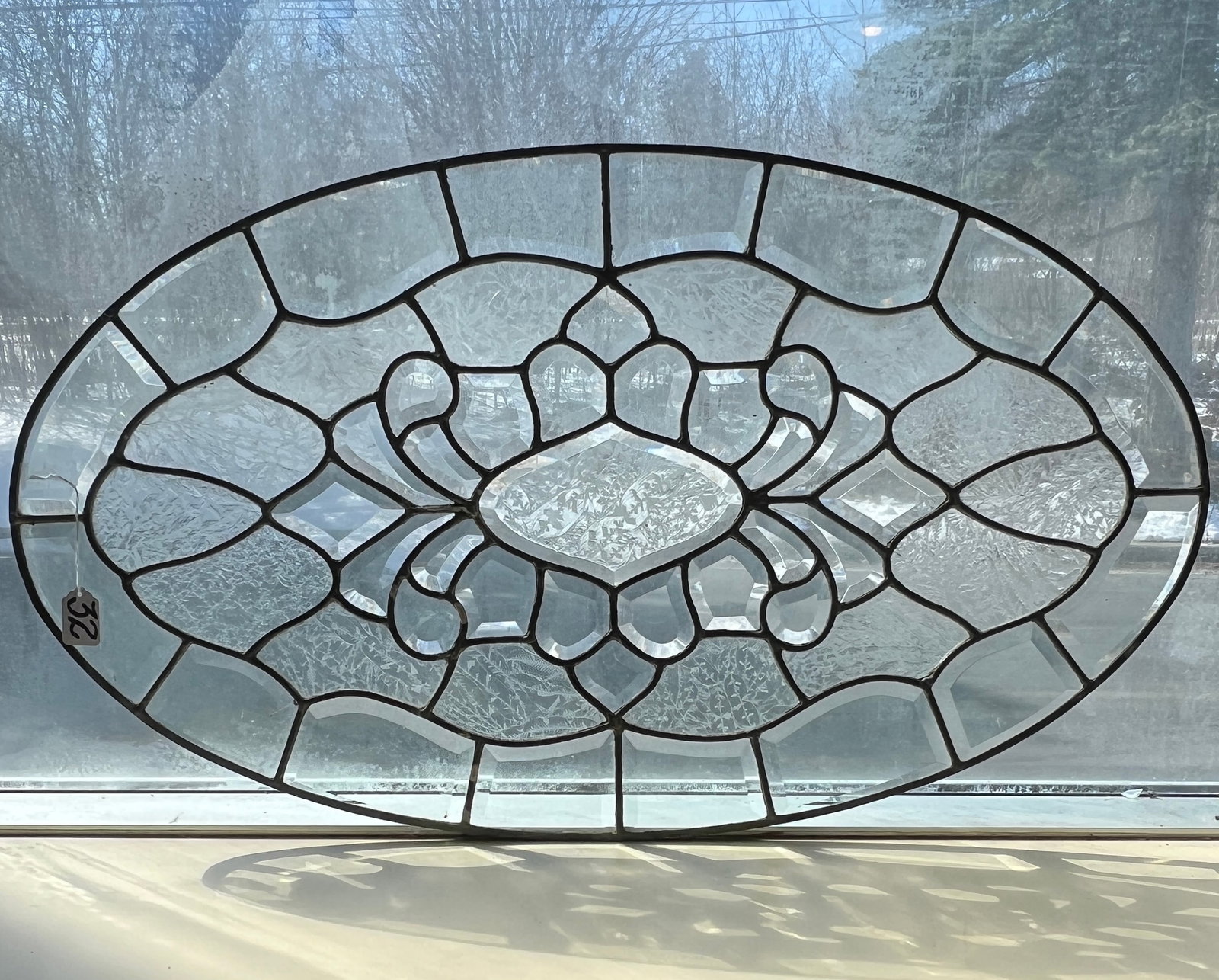 Victorian Oval Beveled and Frosted Glass Window: An elaborate Victorian oval leaded glass window. It features an exterior border of fancy beveled glass surrounding frosted snowflake glass to an elaborate center featuring beveled and frosted glass. T