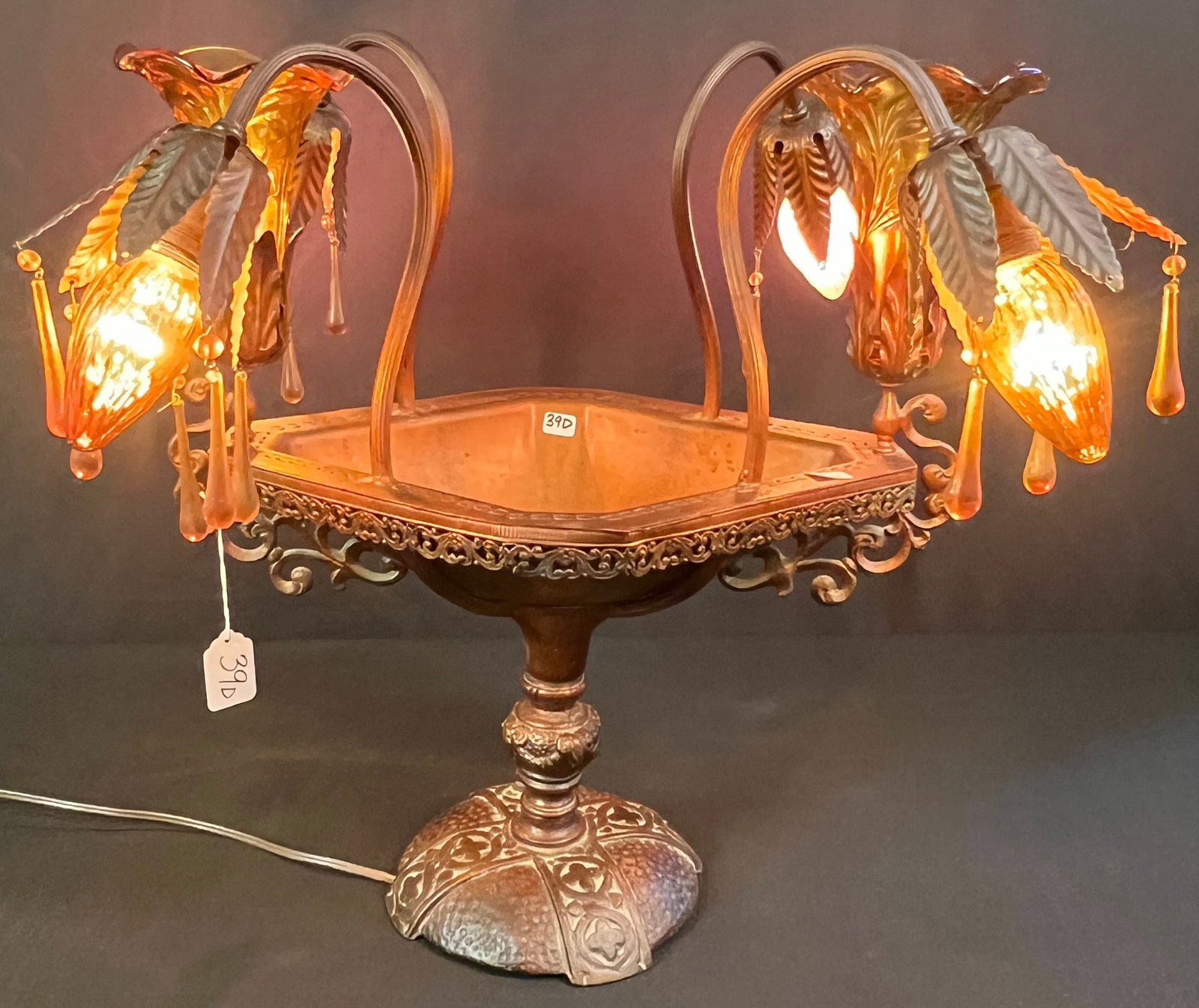 Electrified Epergne Lamp, c.1920s/30s: An Arts & Crafts electrified epergne that features 2 filigreed arms, a hammered solid copper base with Celtic-style design, 4 floral shaped bulbs, with amber floral insets and teardrops. In great,