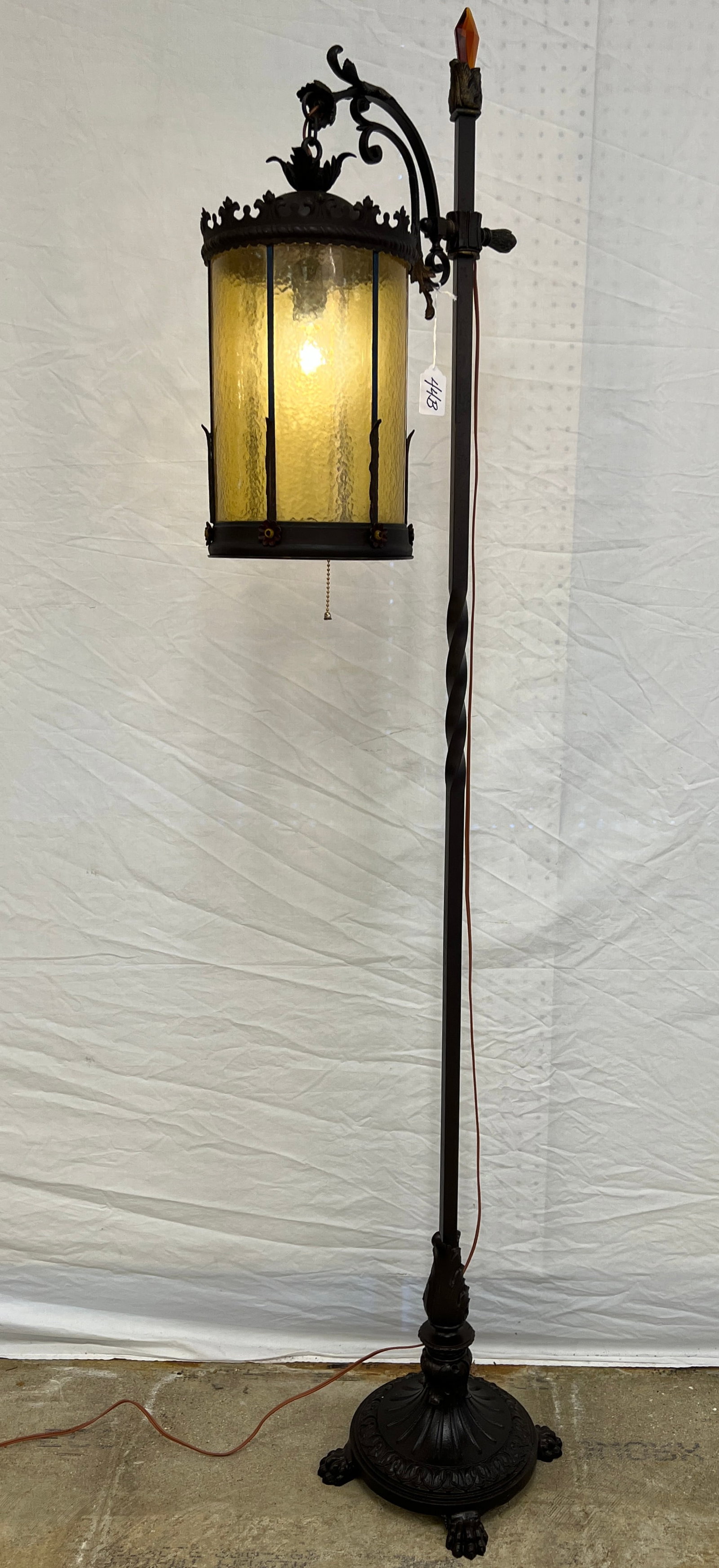 Arts and Crafts Bridge Torchiere Lamp: An Arts and Crafts torchiere lamp with hanging amber glass shade, detailed cast iron base and ornate detailing throughout. A quality piece dating to the 1920s/30s, it measures 70" tall, shade is 15"