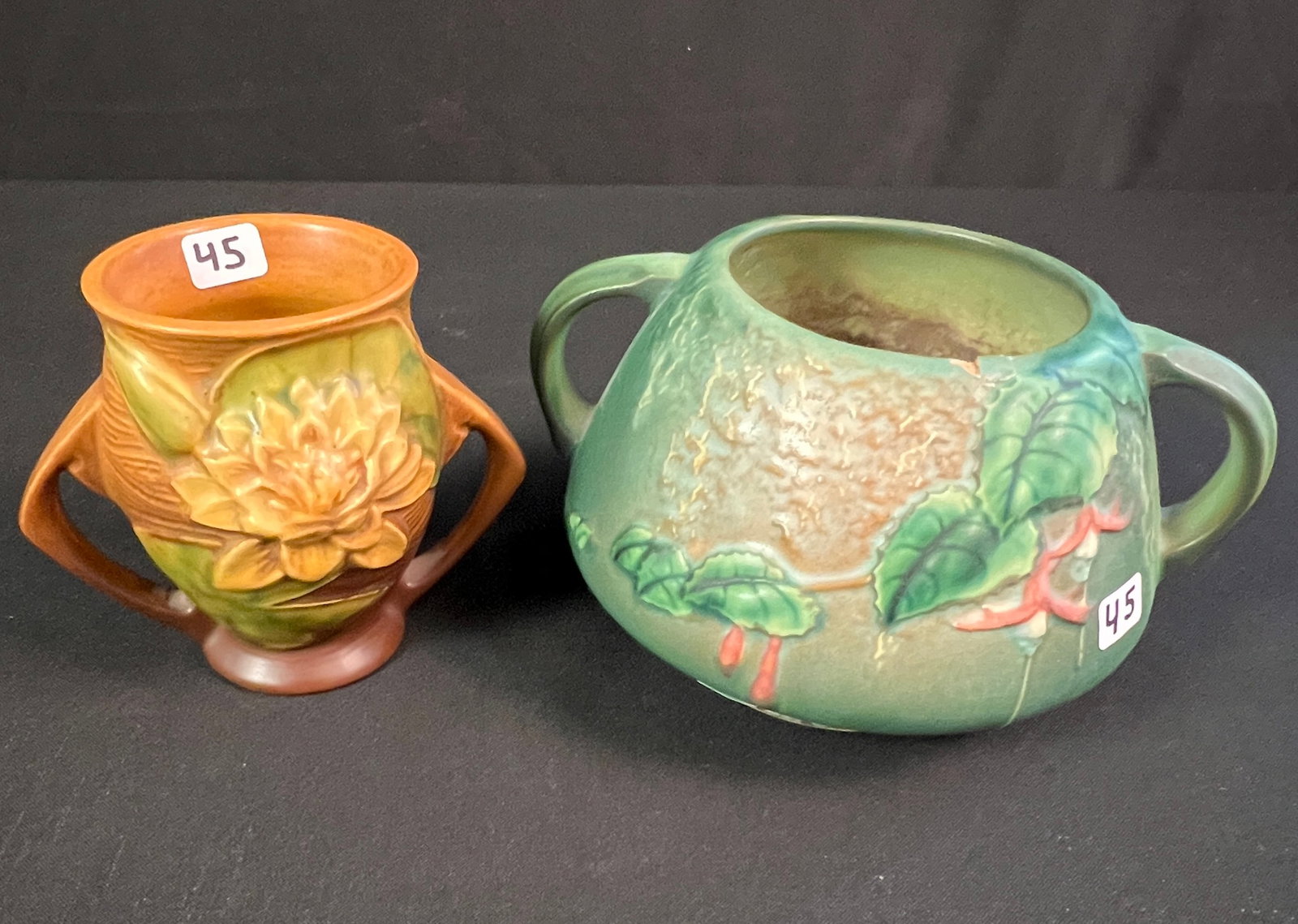 2 Pieces of Roseville Pottery: Two pieces of Roseville to include a "Water Lily" double handled vase (4" tall) and a "Fuchsia" double handled vase (4.5" tall) there is a chip noted on chip and bottom has been drilled.