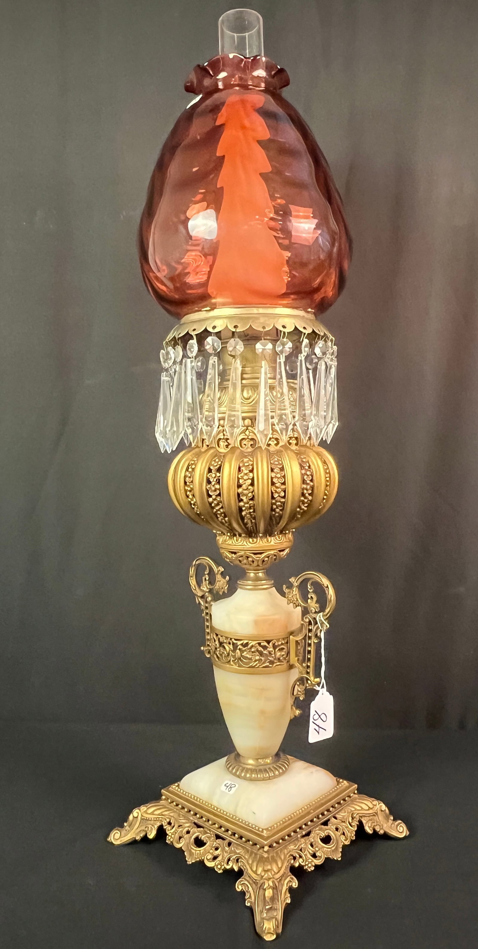 Bradley and Hubbard Elaborate Banquet Lamp: A stunning Bradley and Hubbard bronze and alabaster banquet lamp featuring elaborate filagree, bronze urn handles, crystals and cranberry drape shade. This lamp is in excellent condition, it measures 